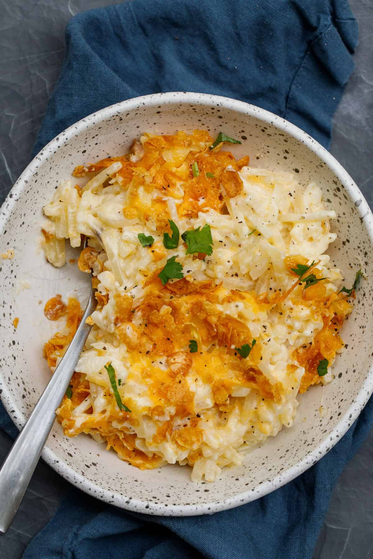 This cheesy hash brown casserole is so flavorful and delicious. A super easy breakfast recipe that is perfect for a crowd. A bowl of hash brown casserole.