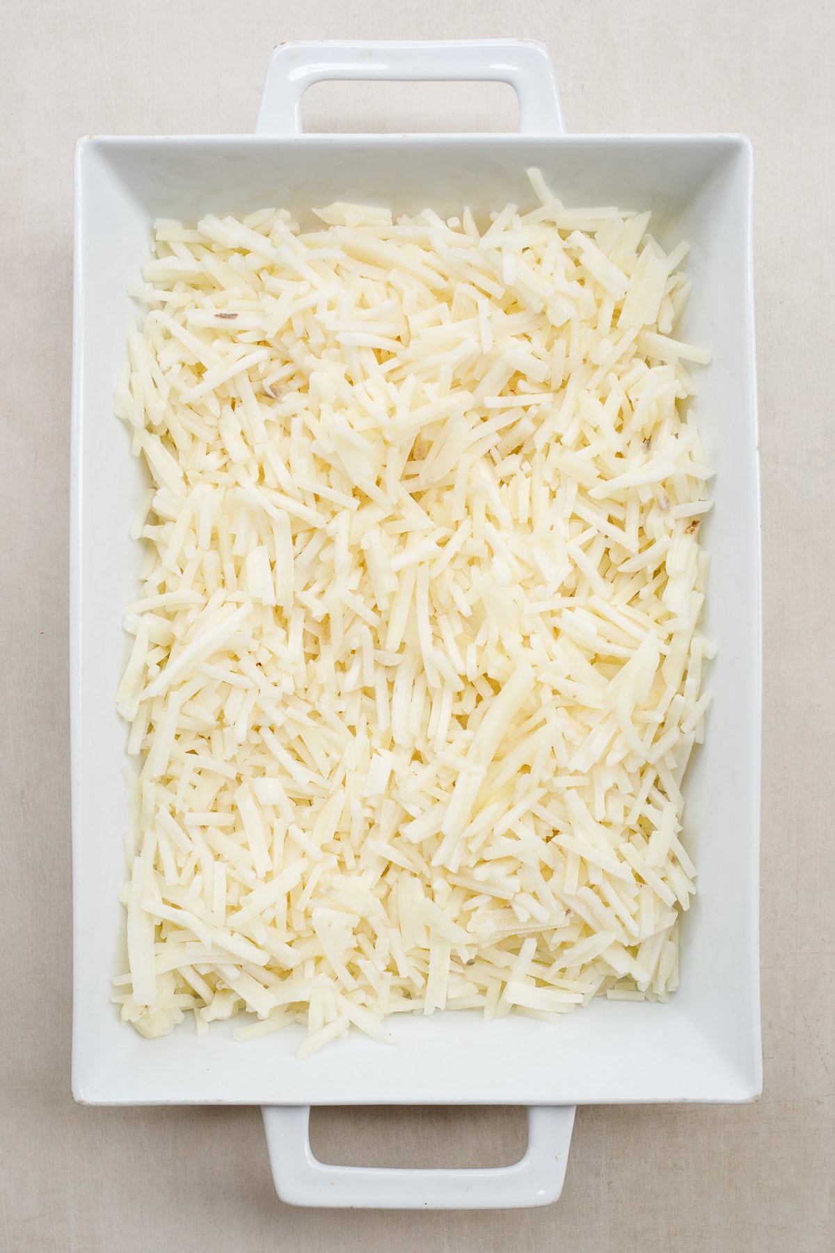 This easy hash brown casserole recipe makes the perfect comfort food that you can enjoy for breakfast. A casserole dish with the hash brown casserole spread.