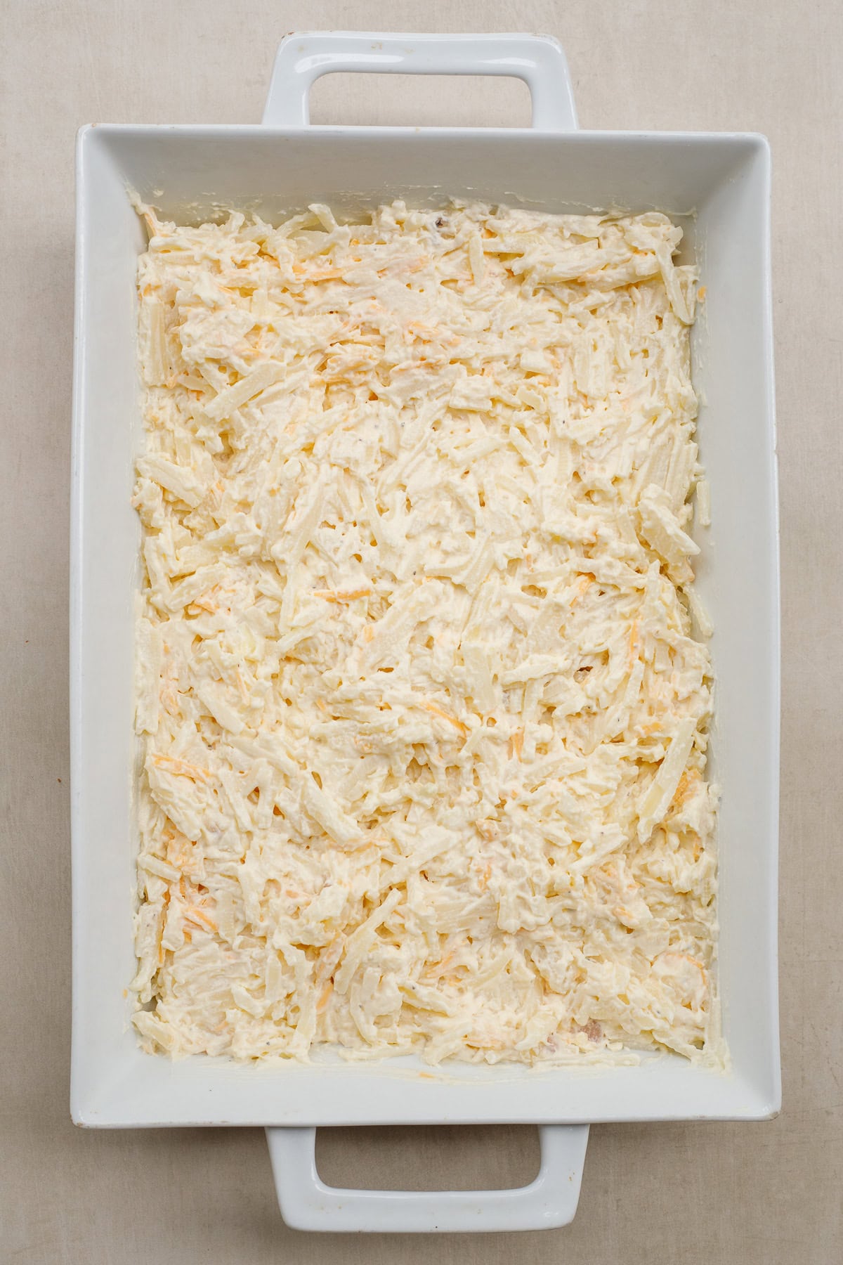 Nothing beats a homemade hash brown casserole. Tender potatoes, baked in a rich and cheesy sauce. A casserole dish with the creamy shredded potato mixture.