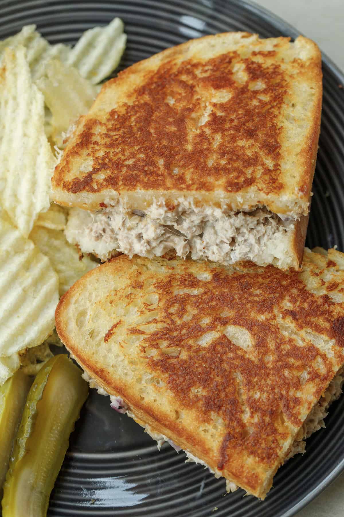 This crispy and cheesy tuna melt sandwich recipe. Perfect healthy and easy lunch. A plate with the golden brown tuna melt sandwich.