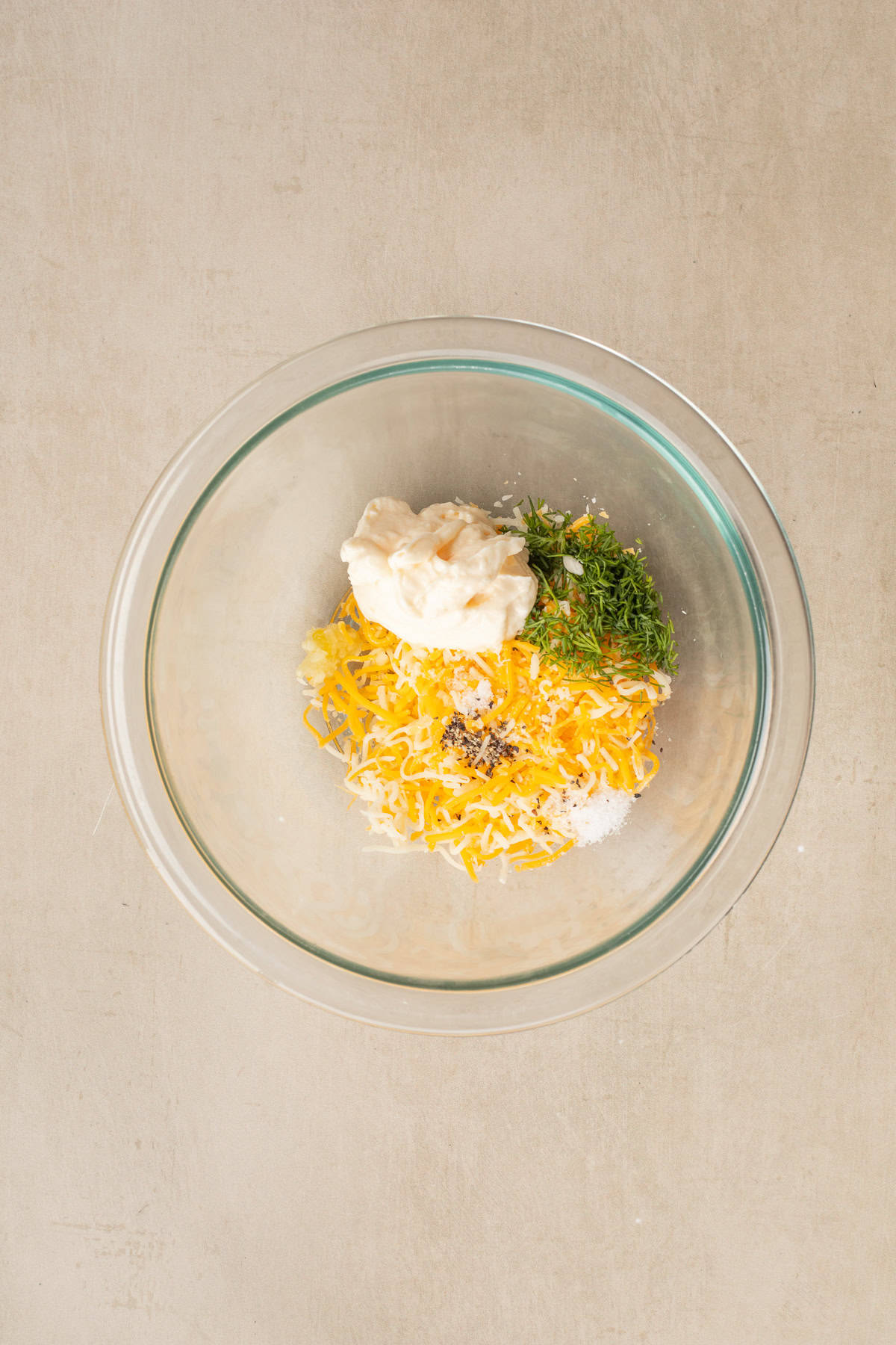 This classic tomato and cheese appetizer makes the perfect starter for parties and potluck. A glass bowl with the tomato spread mixture.