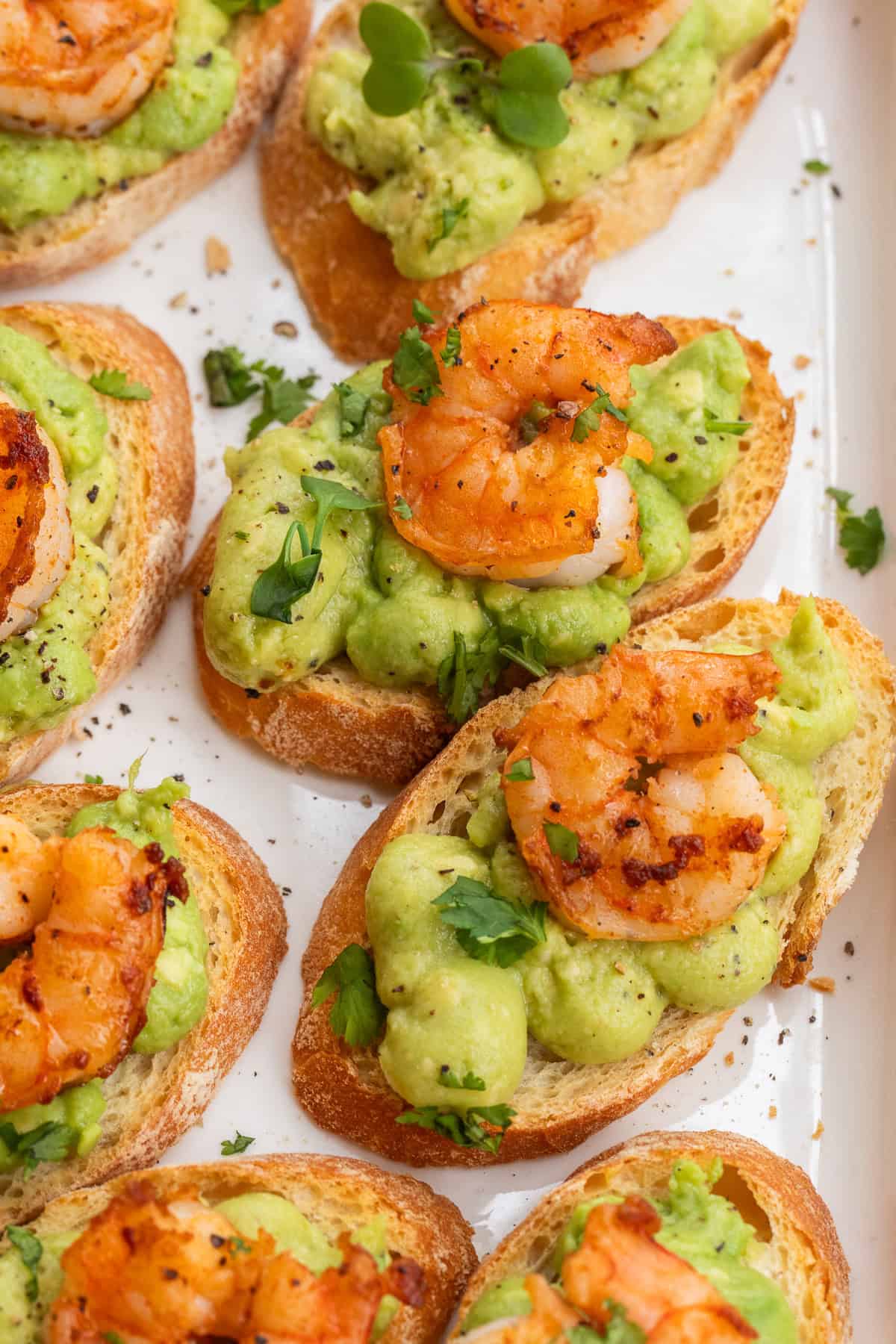 The shrimp and avocado crostini arranged on a serving dish.