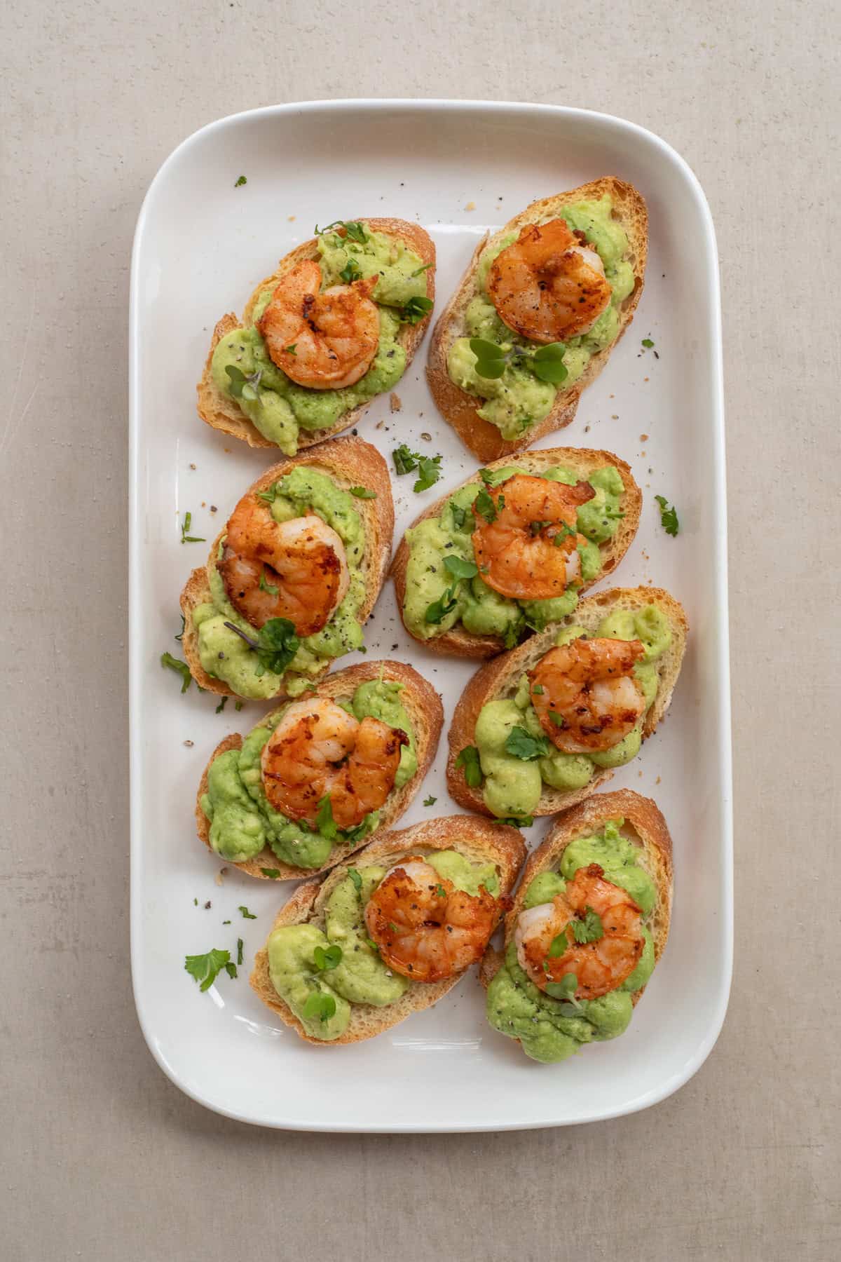 These shrimp and avocado canapes make the perfect easy and delicious appetizer that is sure to please a crowd. A tray of the finished shrimp and avocado canapes.