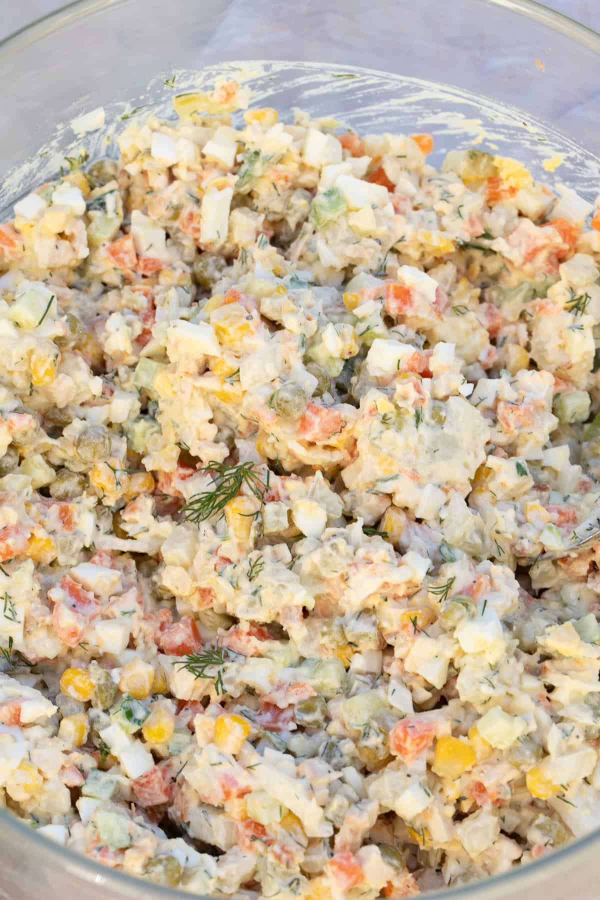 A homemade chicken olivye is a simple variation on the classic olivier salad. A large bowl of creamy chicken olivye.