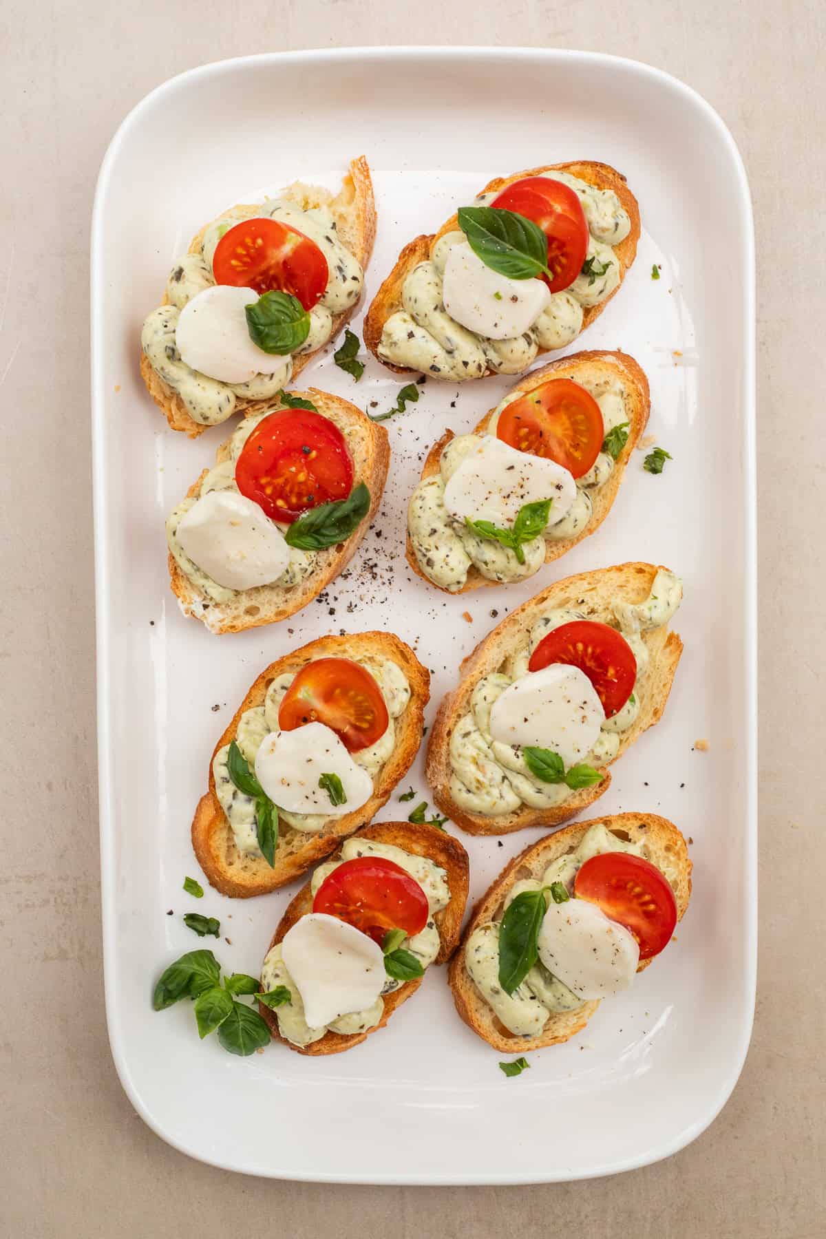 Our pesto and tomato canapes make the perfect appetizer and they are so easy to make! Perfect for a party, potluck, or brunch! A tray with the pesto tomato canapes.