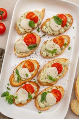 A serving dish with the tomato and pesto canapes.
