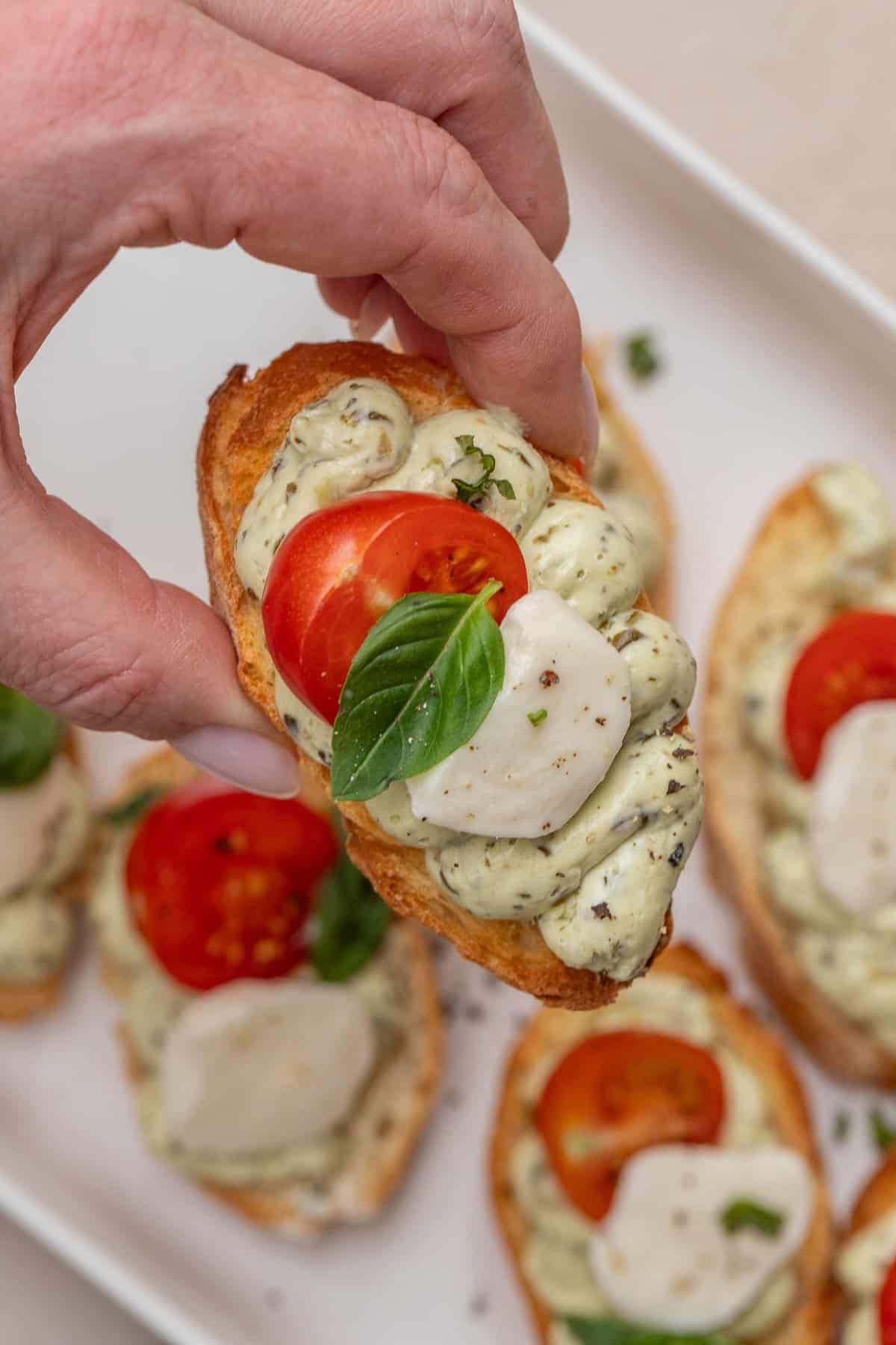 Classic pesto and tomato canapes make the perfect finger food. The crispy canape with a pesto, tomato, and cheese topping.
