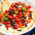 A serving bowl with the baked ricotta tomato dip.