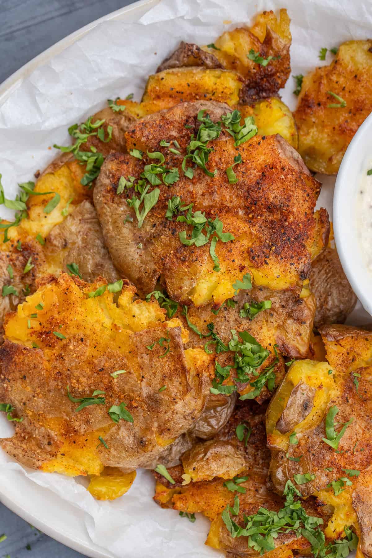 Crispy smashed potatoes make the perfect side dish. Yukon gold potatoes are boiled, smashed, and roasted to a crispy finish. Crispy smashed potatoes garnished with fresh herbs.