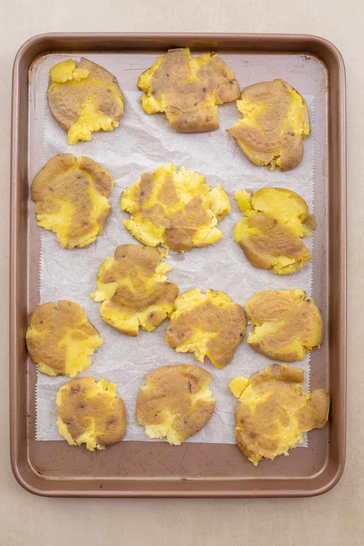 Smashed Potato Recipe Ready in less than an hour. A baking sheet with the cooked potatoes smashed down.