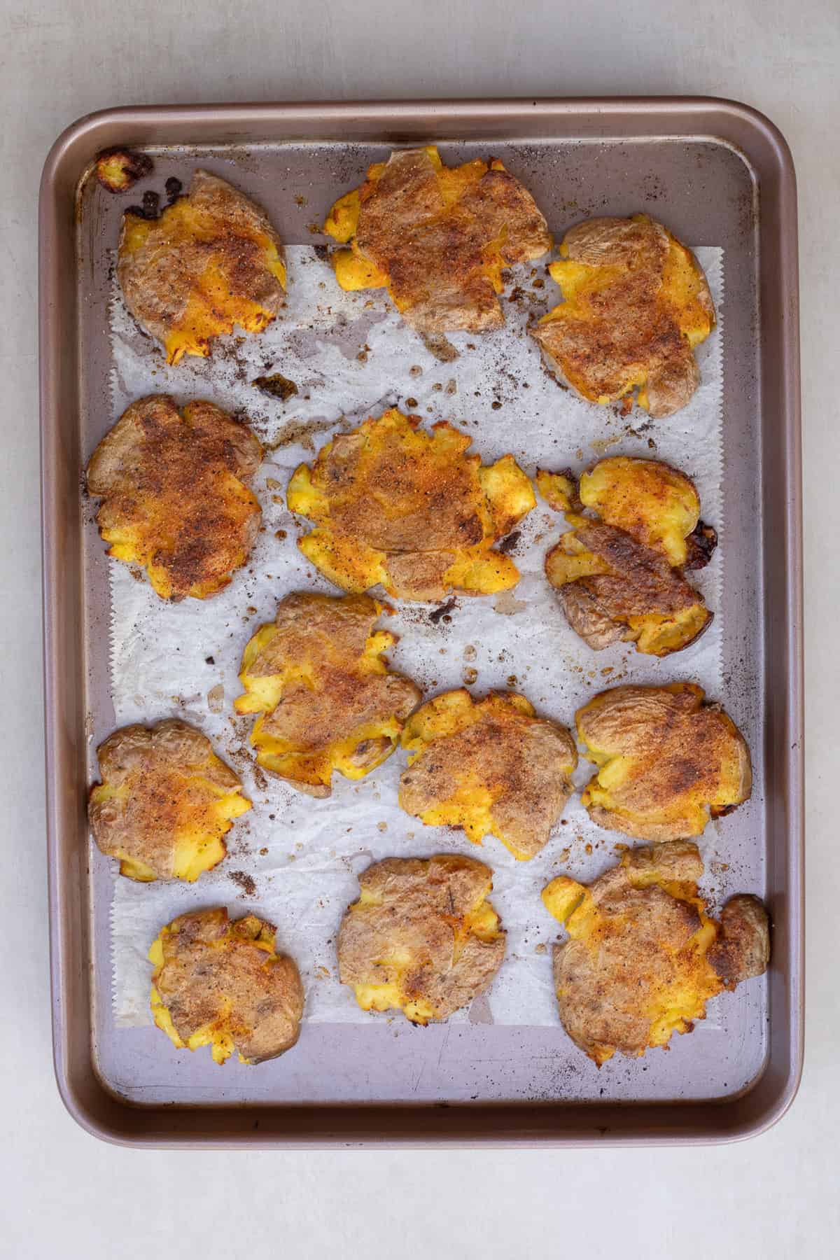 This easy smashed potato recipe makes the perfect side dish from scratch. A baking sheet with the roasted smashed potatoes.