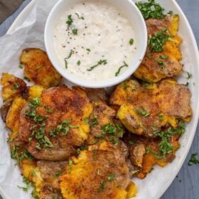 A plate with the smashed potatoes and garlic aioli.