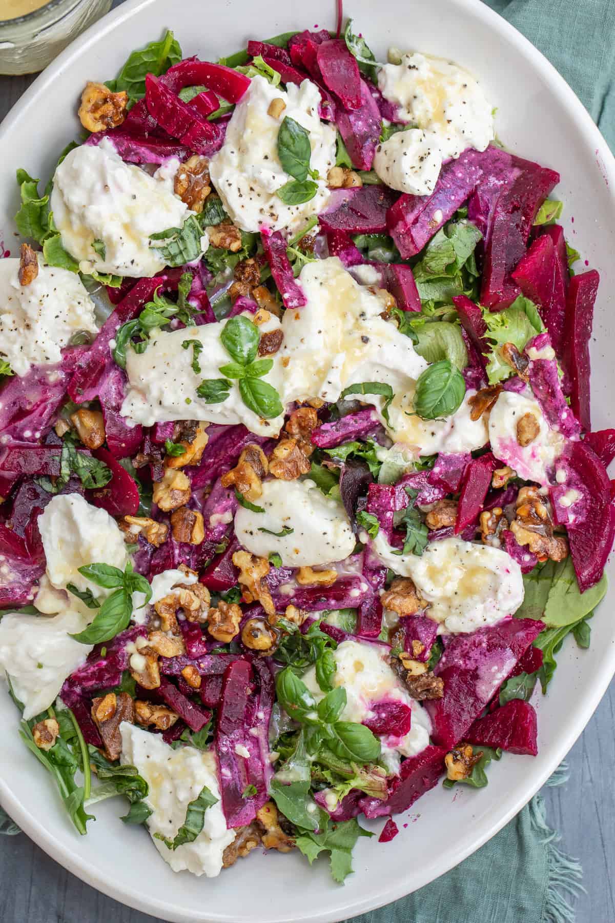 This Beet Salad Is So Good You’ll Make It Weekly A large salad plate with beet burrata salad topped with a homemade dressing.