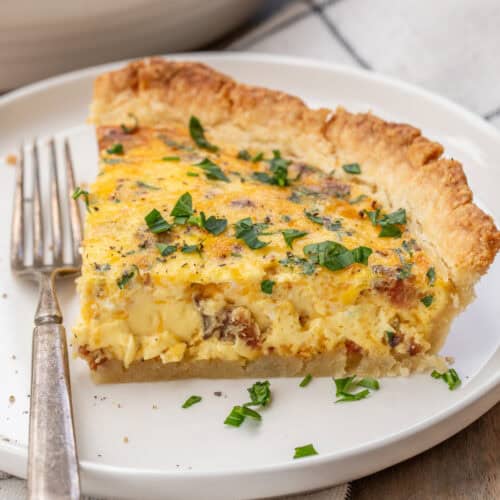 A plate with a slice of baked quiche.
