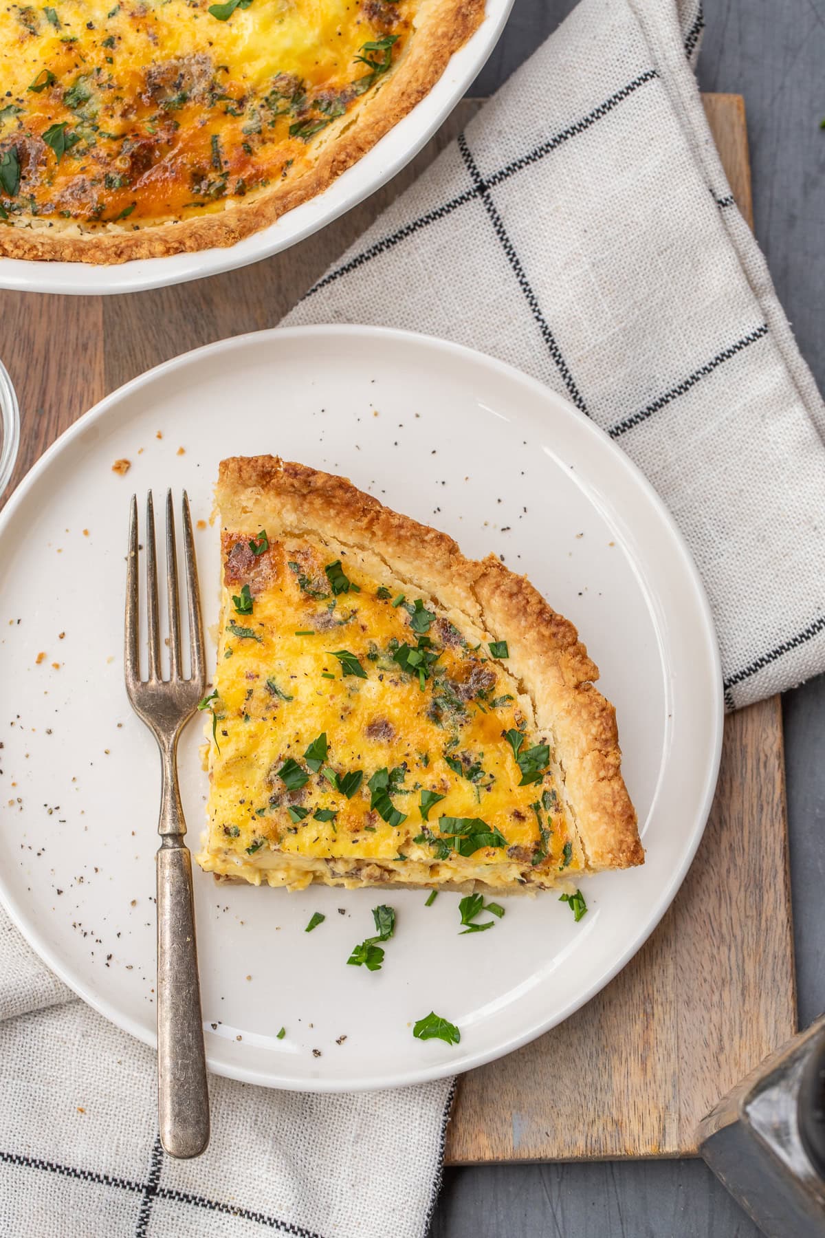 A homemade savory quiche makes the perfect breakfast for a crowd. A plate with a baked quiche in the pie crust.