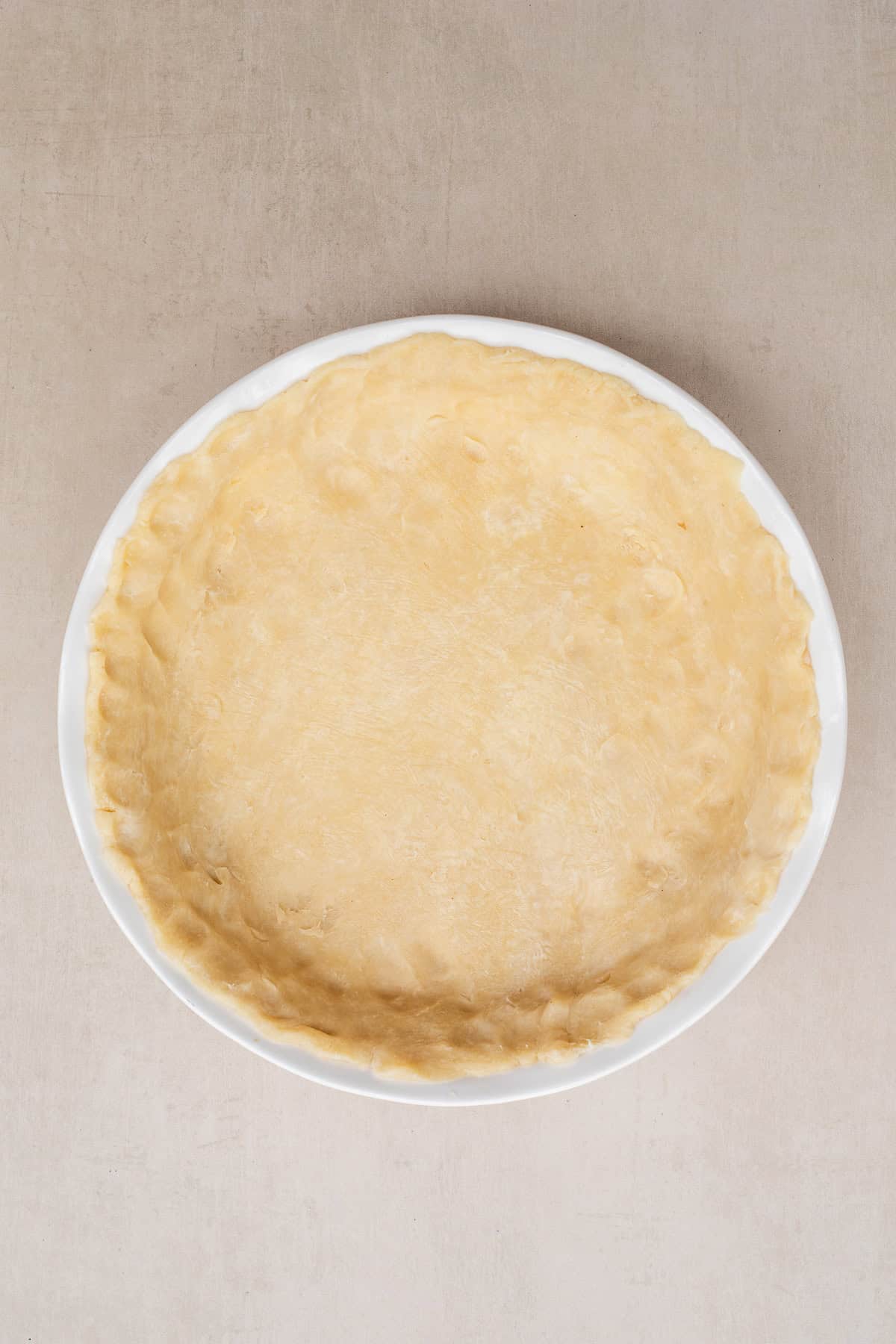 A homemade pie crust takes this simple quiche to the next level. A pie dish with the crimped pie dough.