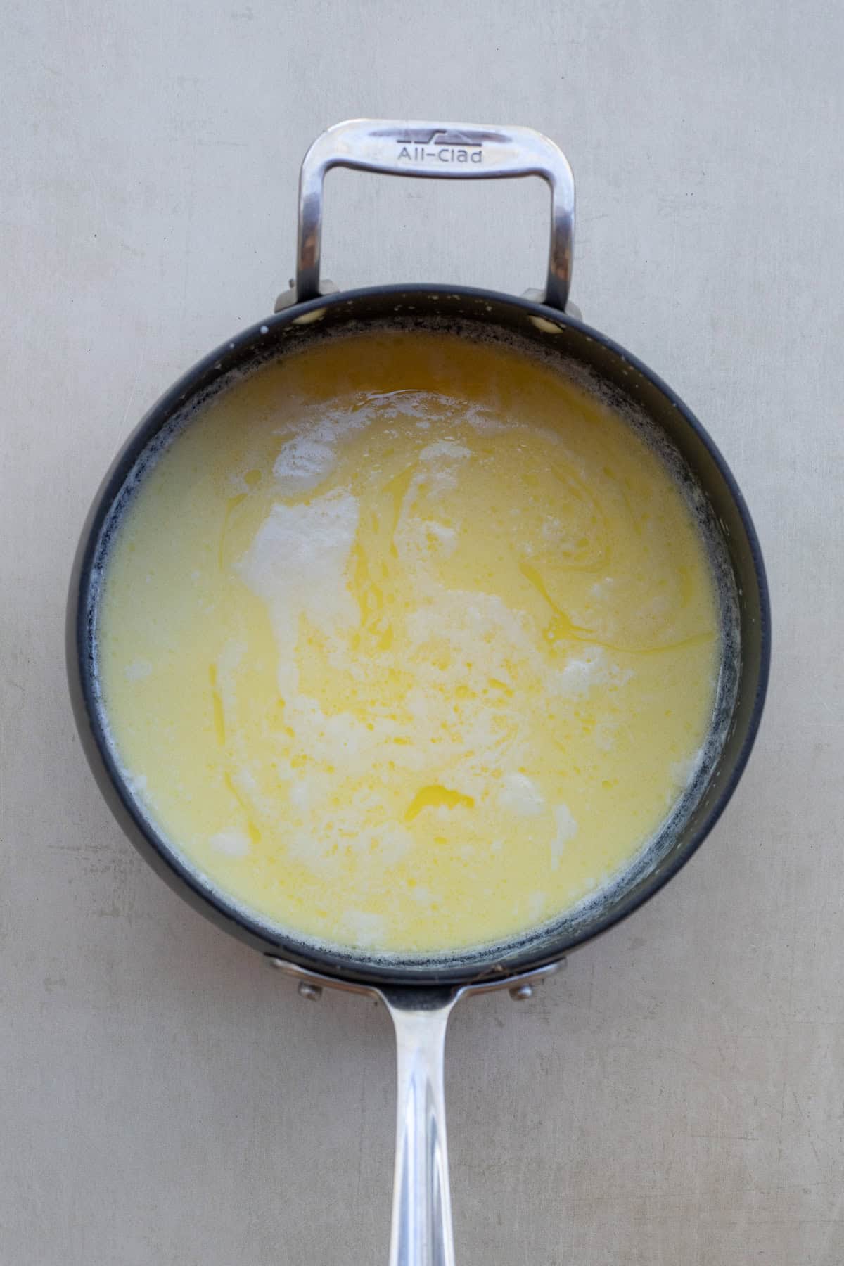 Creamy mashed potatoes with heavy cream turn out extra light and fluffy. A pot with the melted cream and butter mixture.