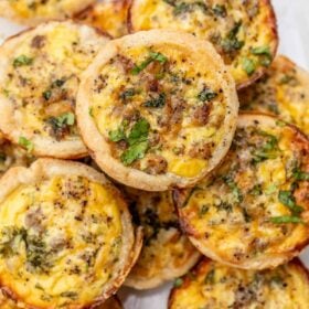 Loaded mini quiches stacked on top of each other.