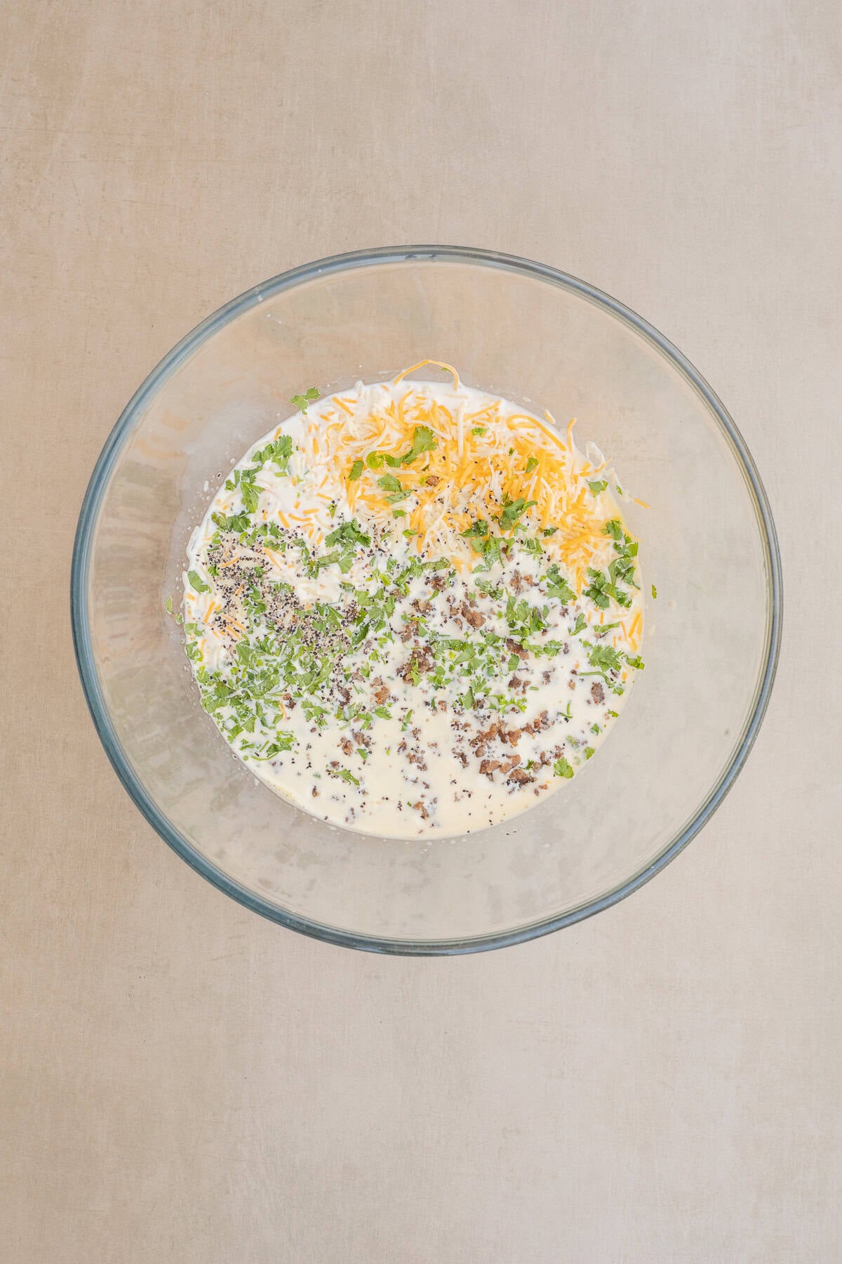 Simple Mini Quiche Recipe in Muffin Tin A glass bowl with all of the mini quiche ingredients.
