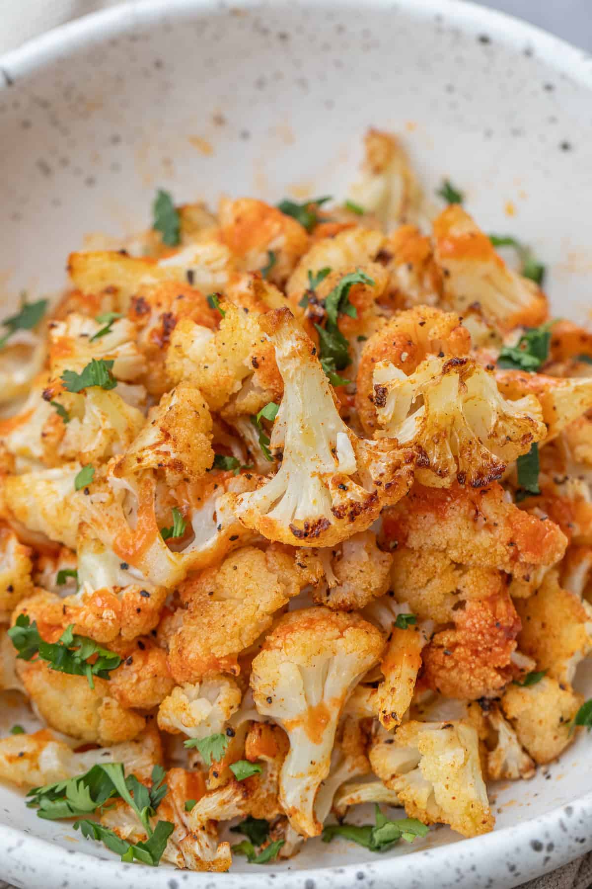 Easy Air Fryer Cauliflower (Perfectly Golden & Delicious) Crispy cauliflower made in the air fryer, served in a bowl.