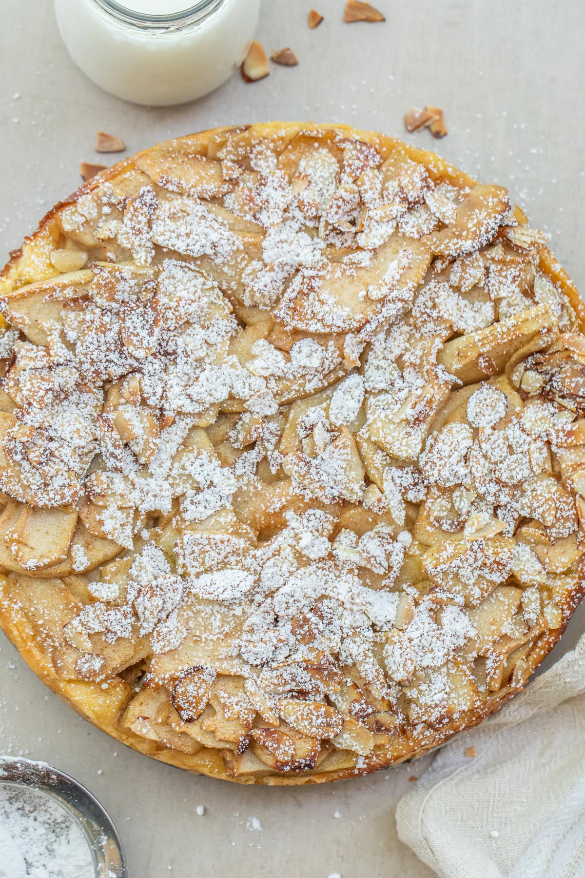 A baked bavarian apple torte sprinkled with powdered sugar.
