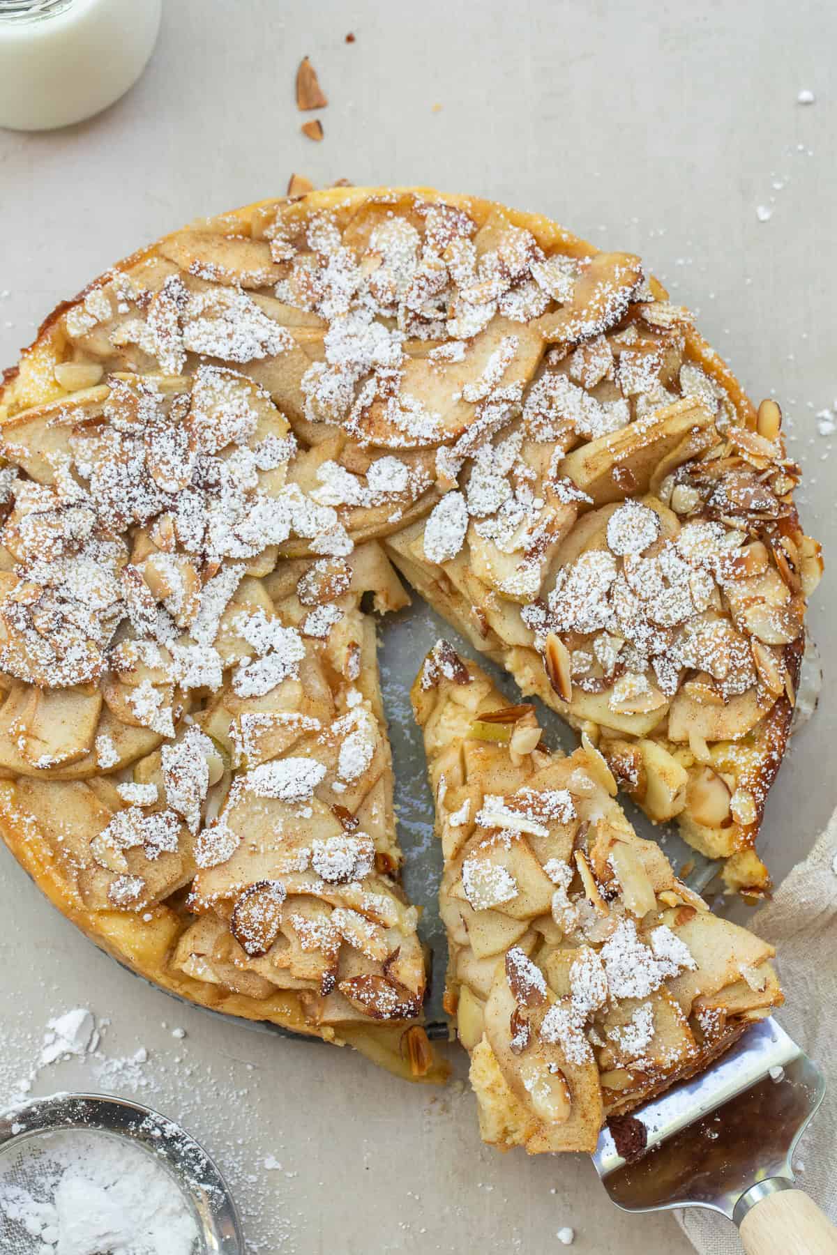This homemade Bavarian apple torte is layered with buttery crust, creamy filling, and soft cinnamon-sugar apples. A bakery-style dessert recipe that’s perfect for entertaining or weekend baking. A whole apple torte with a slice taken out.