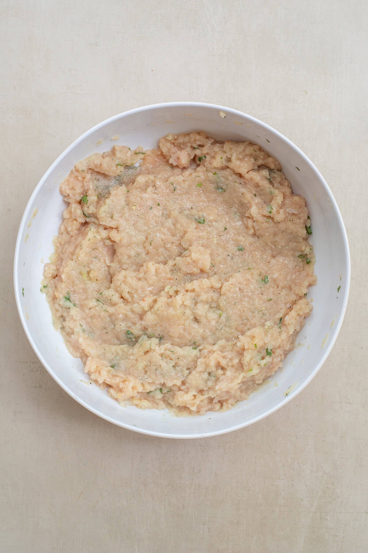 A juicy chicken filling in homemade tortilla dough makes the perfect chicken chebureki. A bowl with the chicken filling mixture.