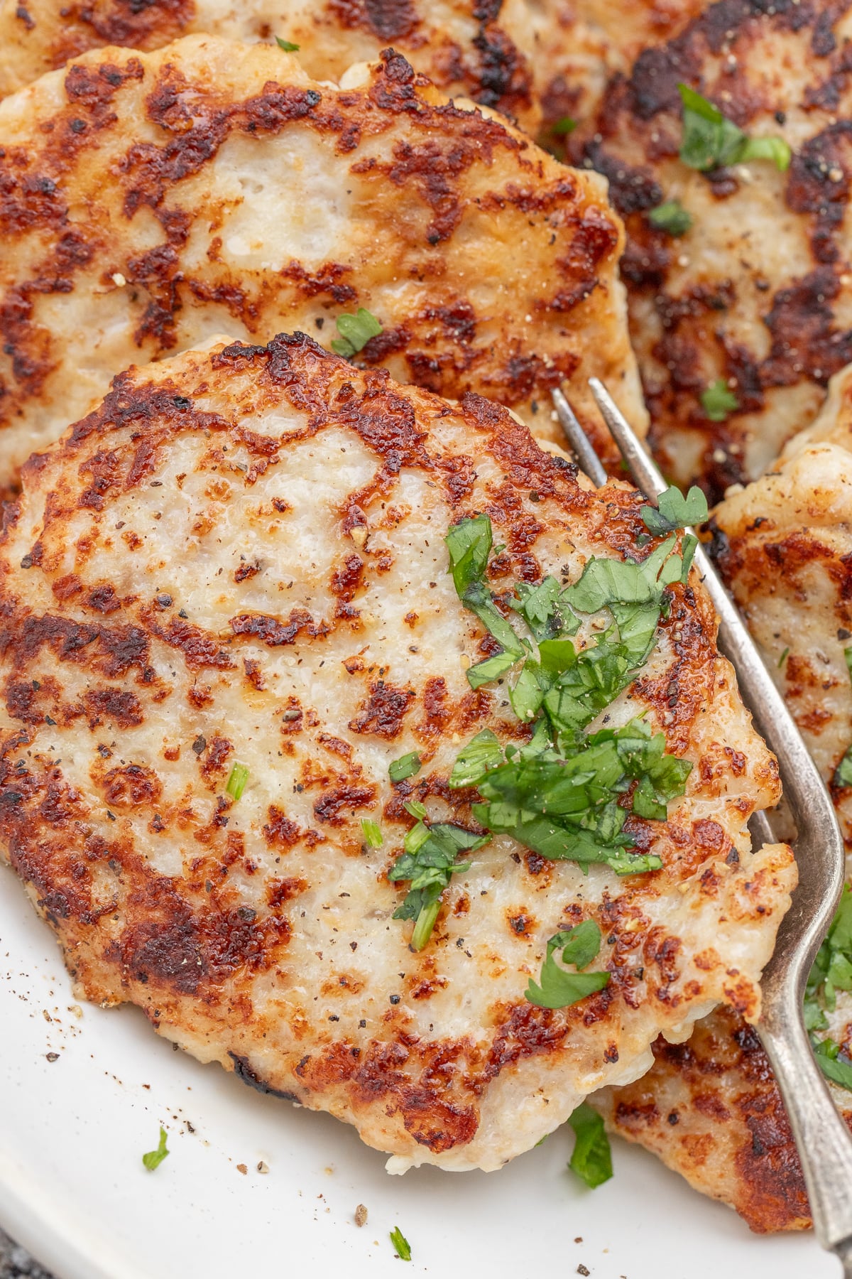 My Go-To Chicken Patties Recipe (So Easy!) A crispy chicken patty garnished with fresh herbs.