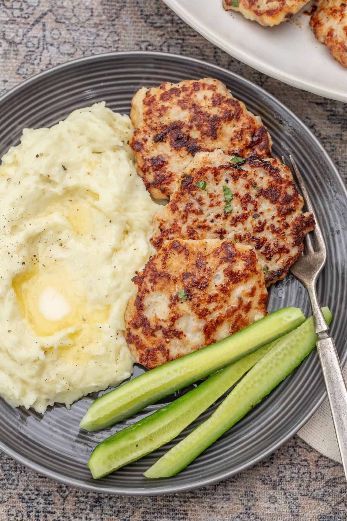 Crispy Chicken Patties Made at Home - The Perfect Meal Prep Recipe A plate with the chicken patties served with creamy mashed potatoes.