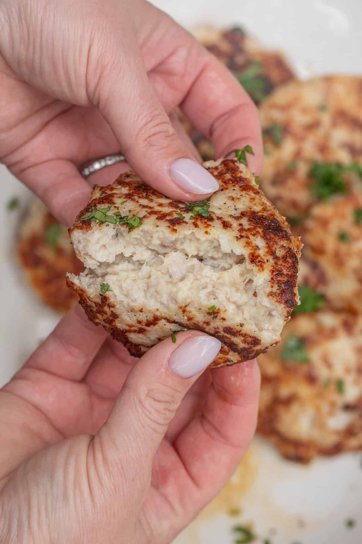 Best Chicken Patties Recipe – Quick and Delicious A chicken patty broken in half to show a juicy cutlet.