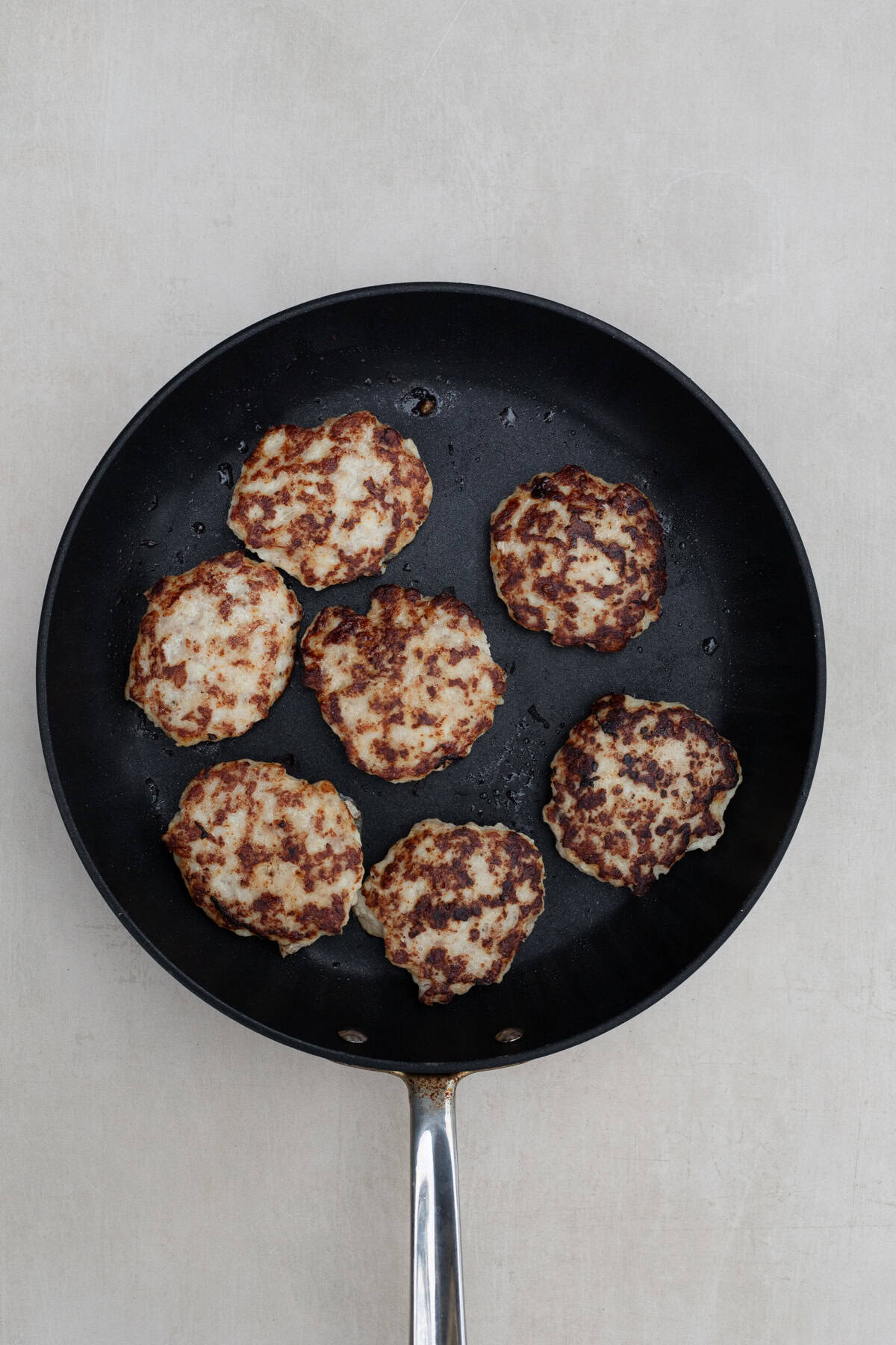 Golden Crispy Chicken Patties in 30 Minutes A pan with the cooking chicken patties.