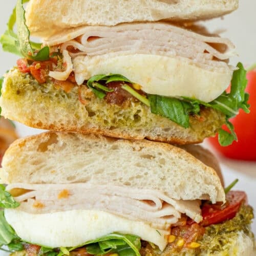 Stacked chicken pesto sandwiches.