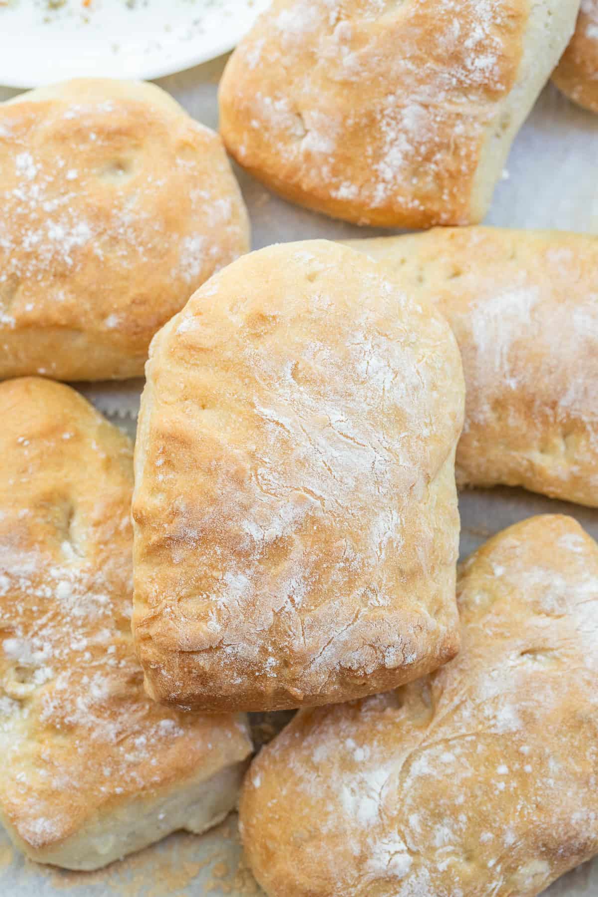 Bakery Quality Ciabatta Rolls at Home The golden brown ciabatta rolls stacked on each other.