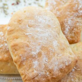Homemade ciabatta rolls stacked on each other.