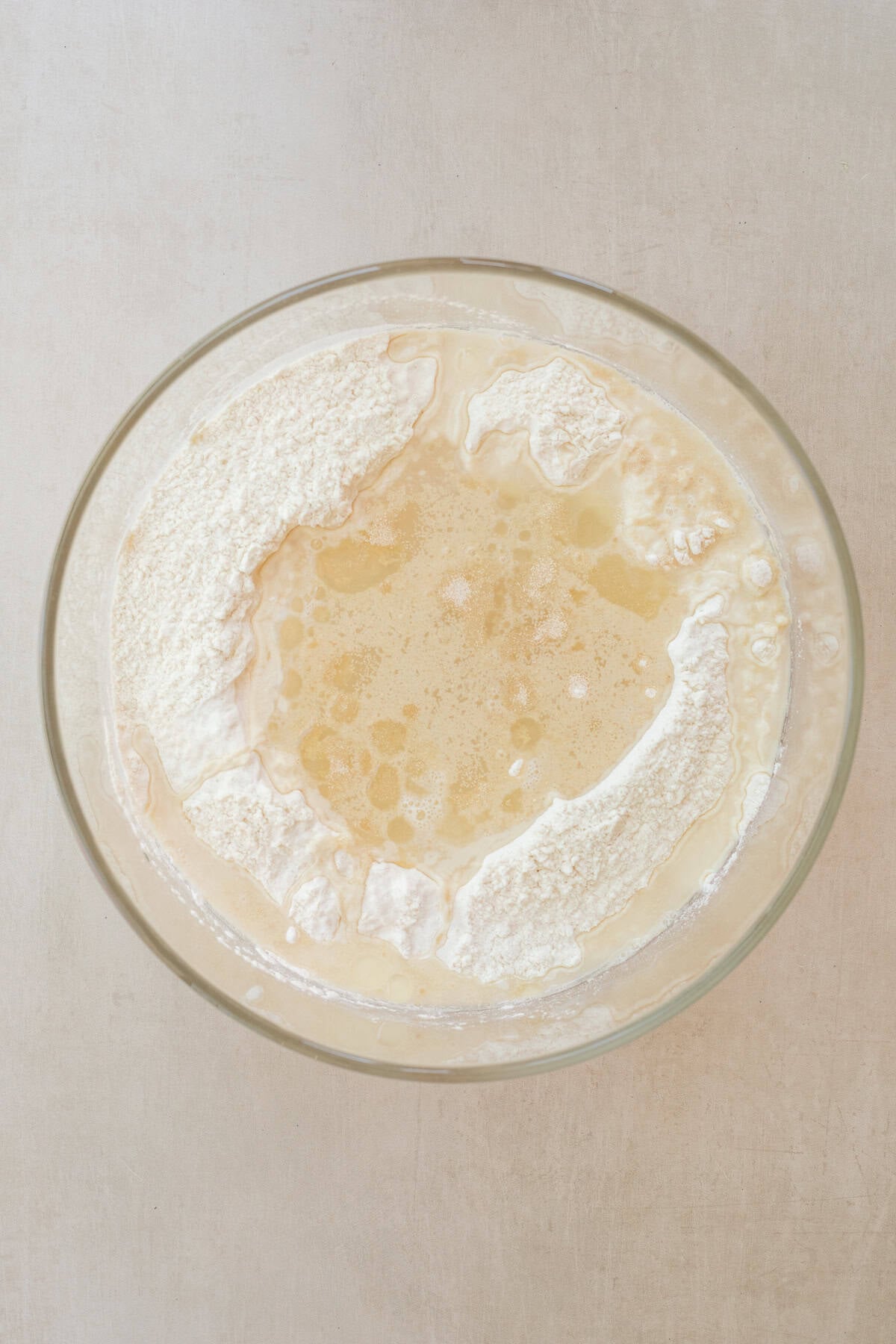 No Mixer Ciabatta Rolls Recipe A bowl with the dry ingredients and yeast blooming in the center.