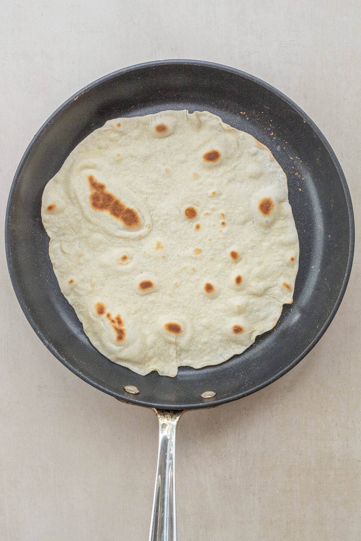 You’ll Never Buy Tortillas Again! Easy Recipe A skillet with the cooking tortilla.