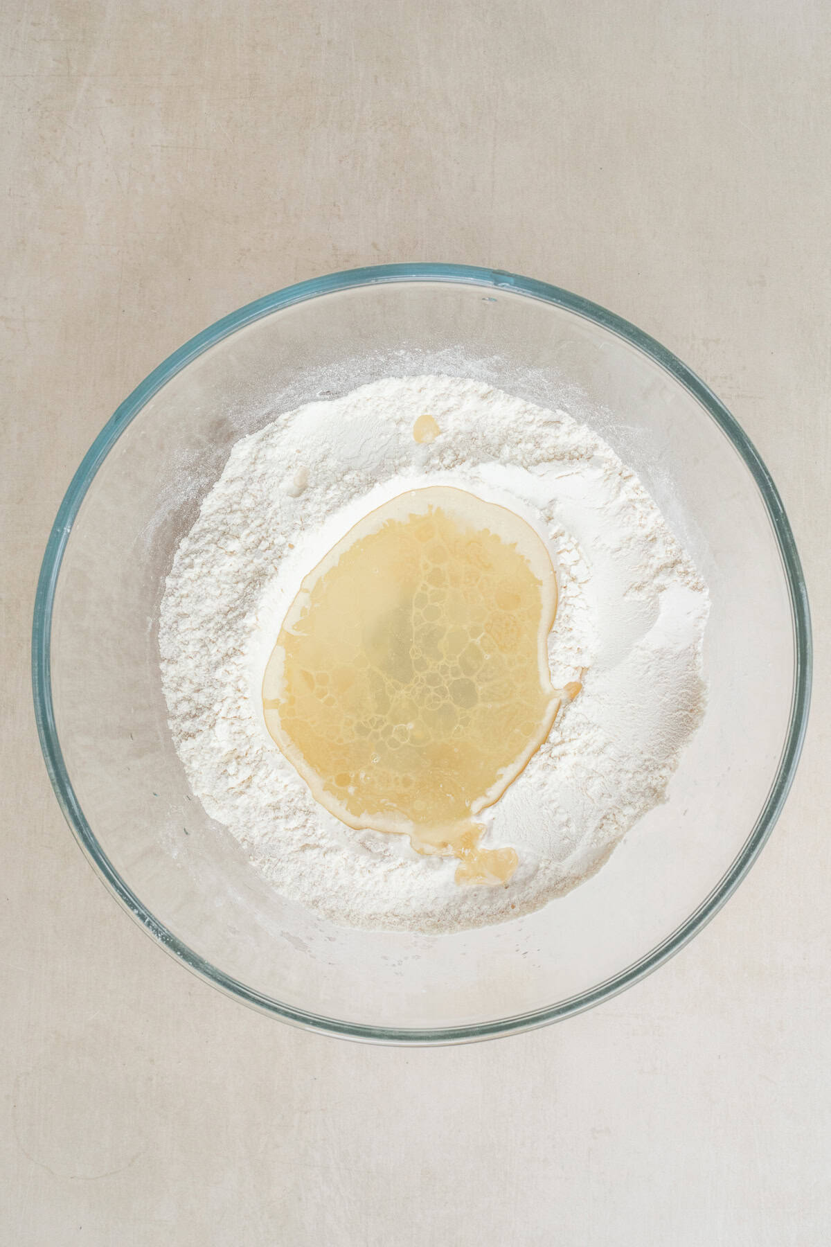 Soft Flour Tortillas Recipe with Oil A bowl of dry ingredients with a well in the center and wet ingredients.