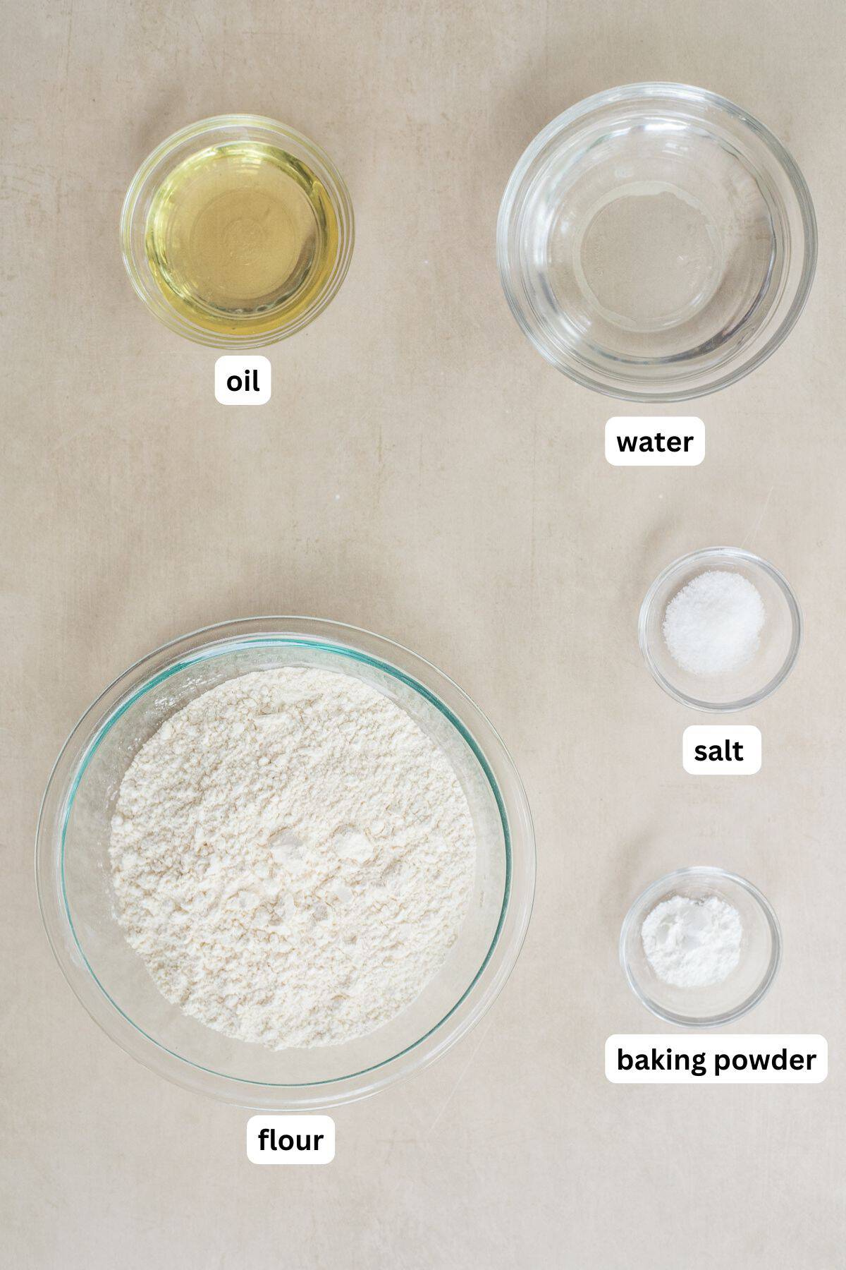 Easy Flour Tortillas (Homemade & Foolproof) All of the ingredients to make homemade tortillas, labeled in bowls.
