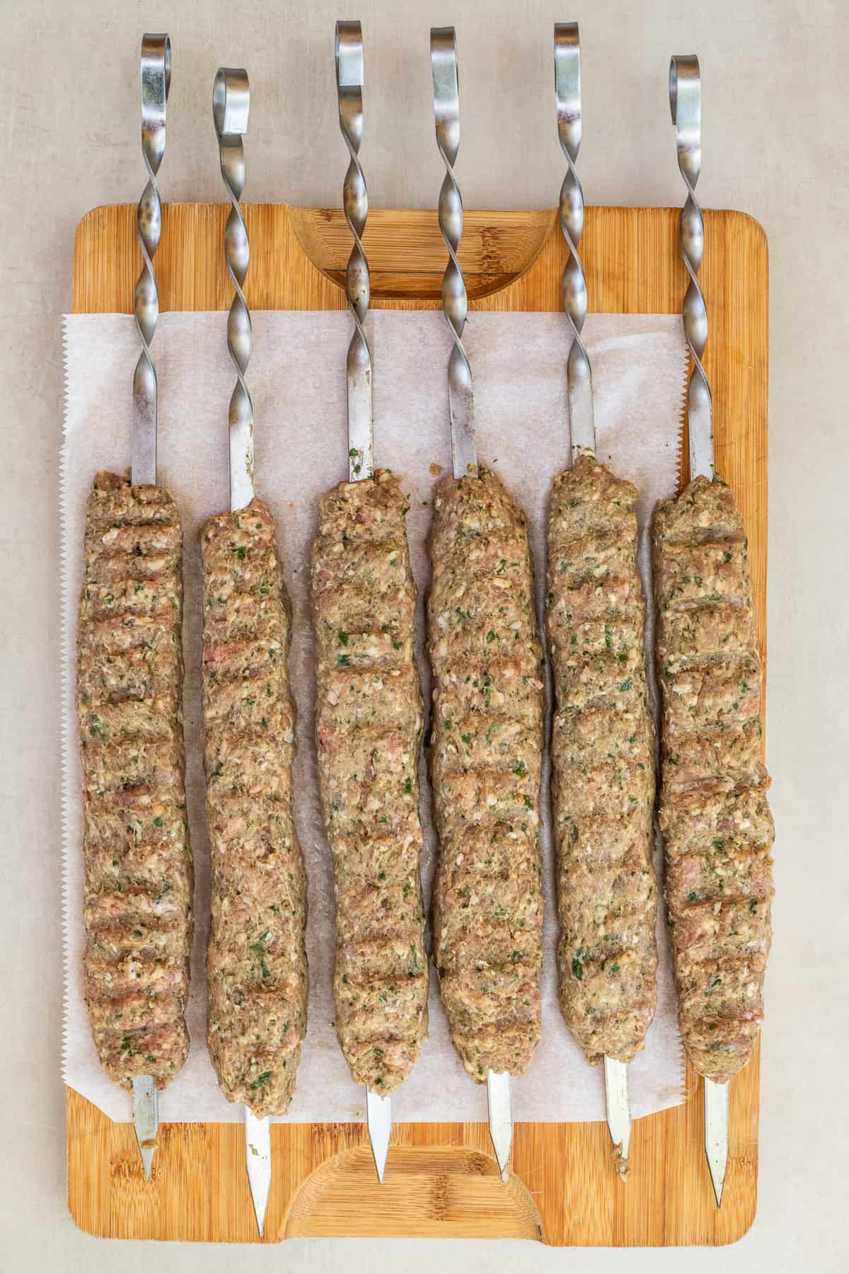 Ground Lamb Kebabs Served with Rice, Pita, or Salad The lamb kebabs shaped around the skewers in a long log.