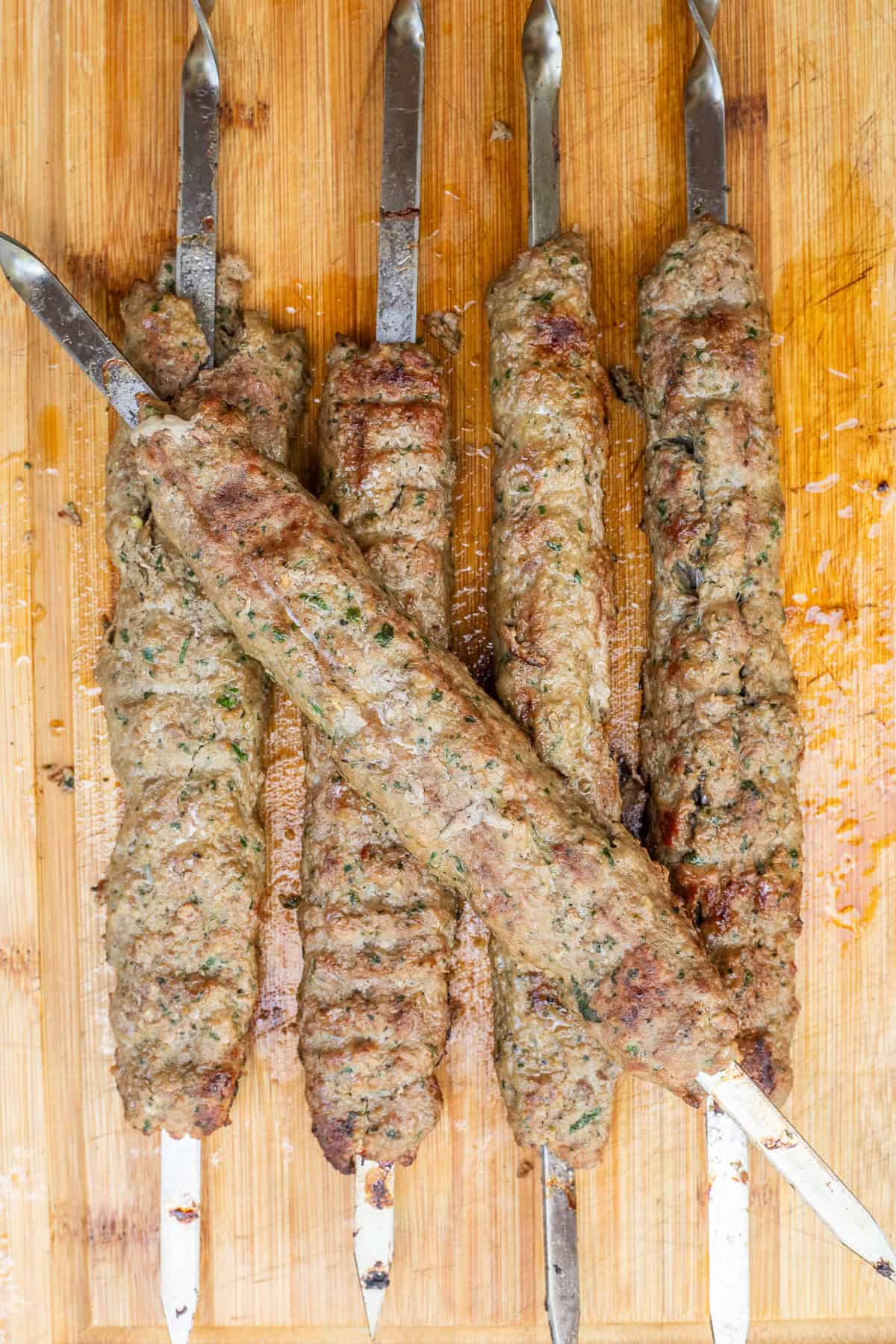 High-Protein Ground Lamb Kebabs Packed with Flavor A cutting board with the grilled lamb kebabs.