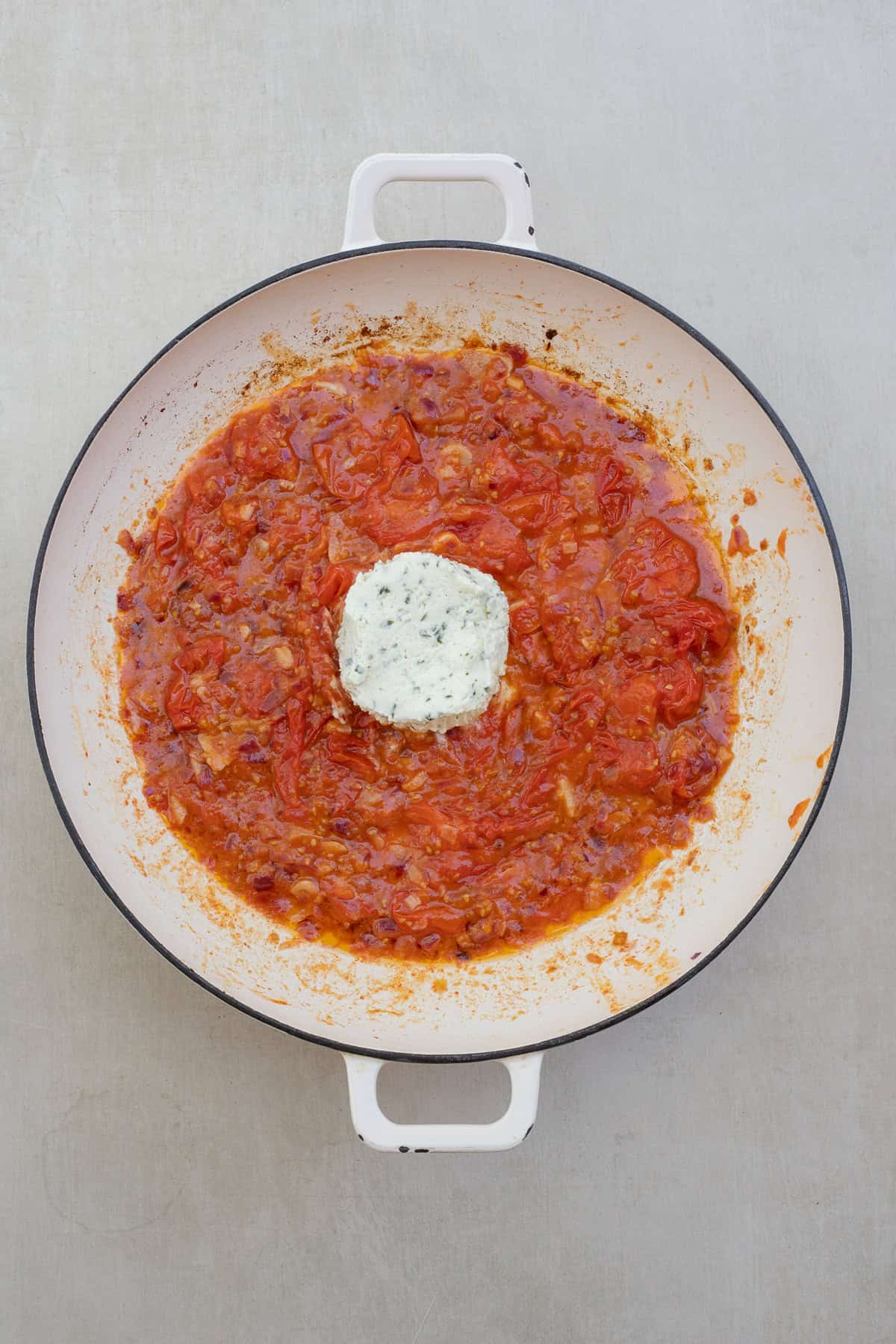 Easy Weeknight Boursin Tomato Pasta A pot with the tomato pasta sauce and a block of boursin cheese in the center.
