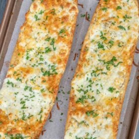 A baking sheet with the baked cheesy loaves.
