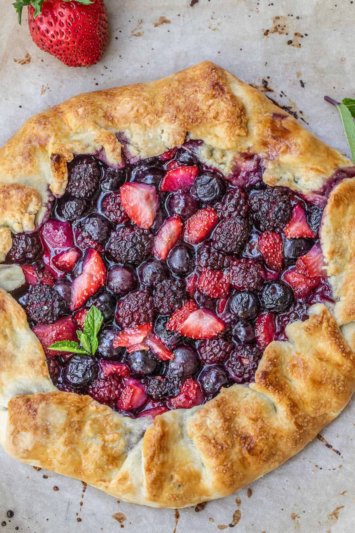 Make this easy galette dough recipe for a tender, flaky crust that comes together quickly. A mixed berry galette garnished with fresh mint.