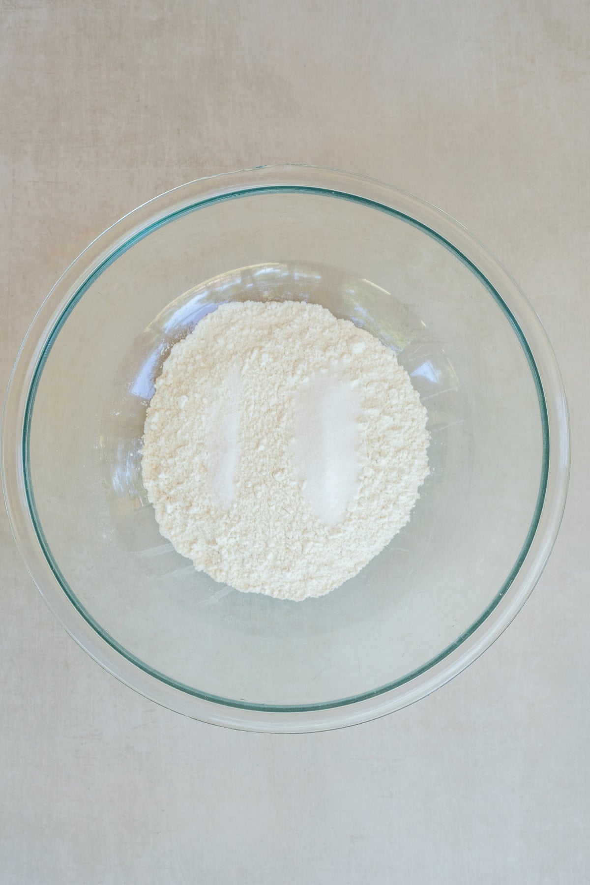 This buttery galette dough is simple to make and perfect for all your favorite galette recipes. A glass bowl of dry galette dough ingredients.