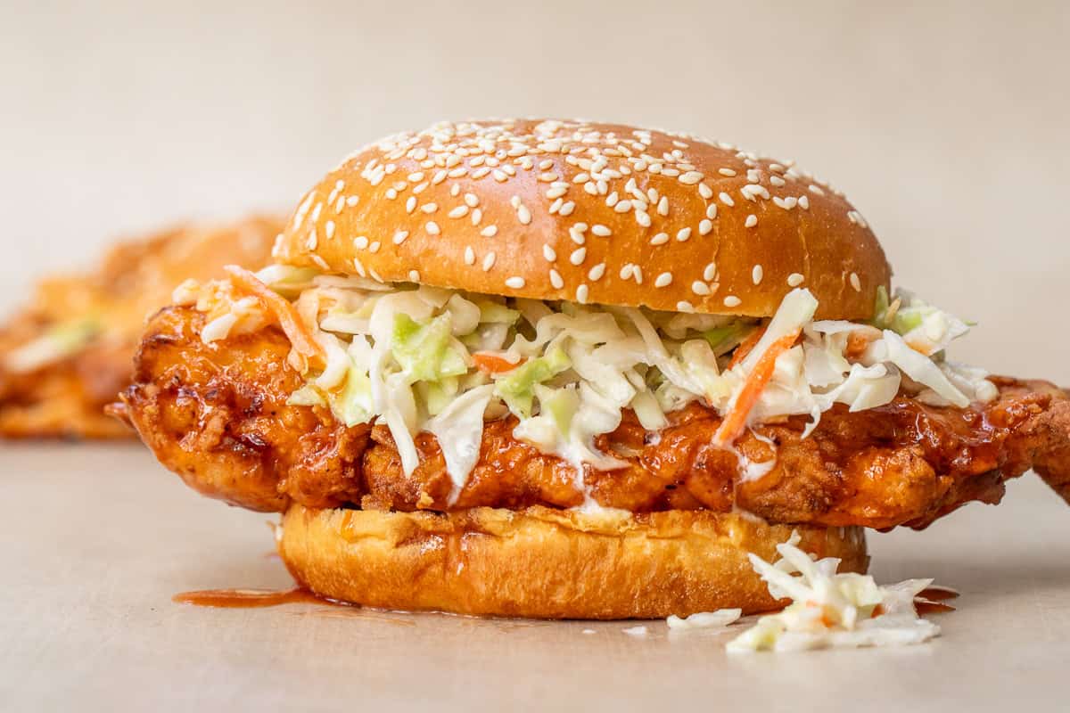 Crispy Chicken Sandwich with Homemade Hot Honey Hot honey chicken patty on a soft bun, topped with crispy coleslaw.