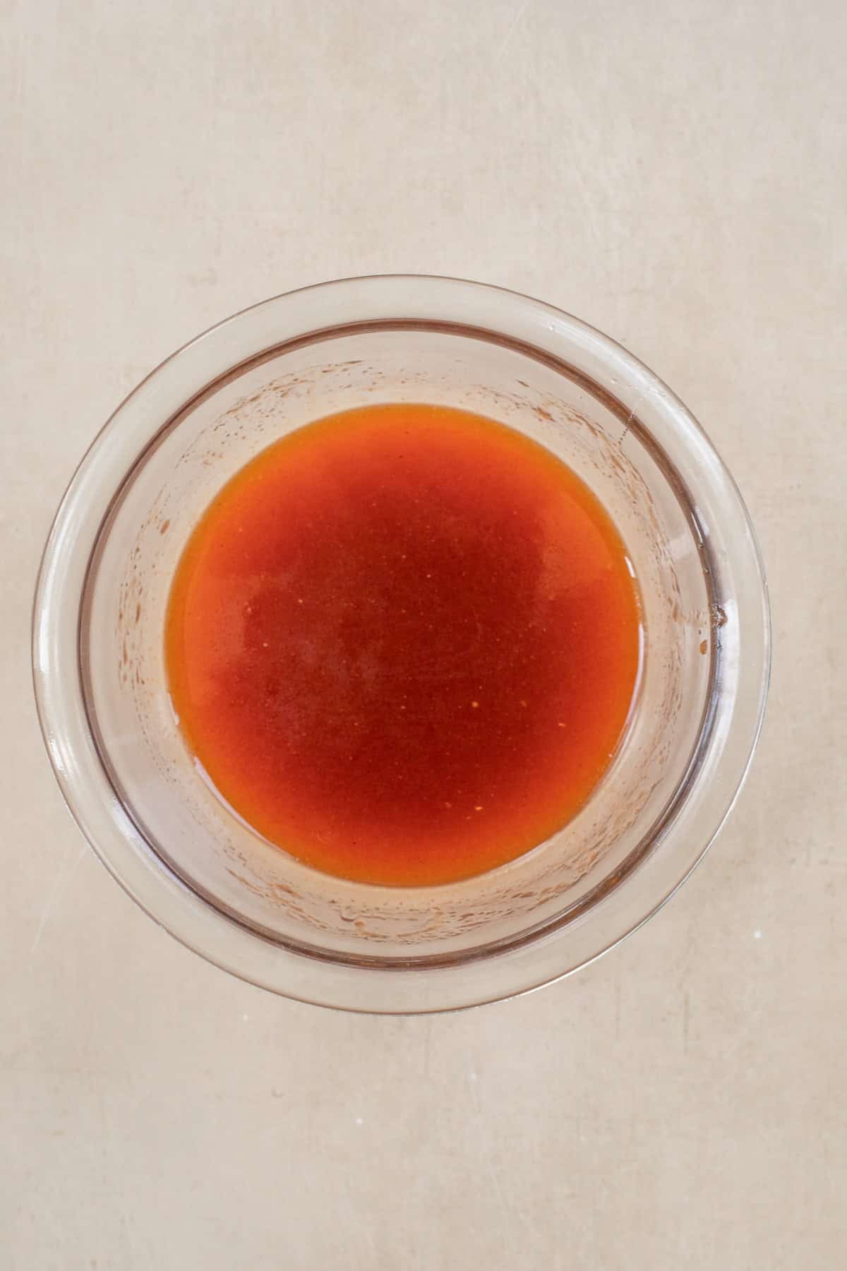 A Classic Hot Honey Chicken Sandwich A glass bowl with the hot honey sauce.