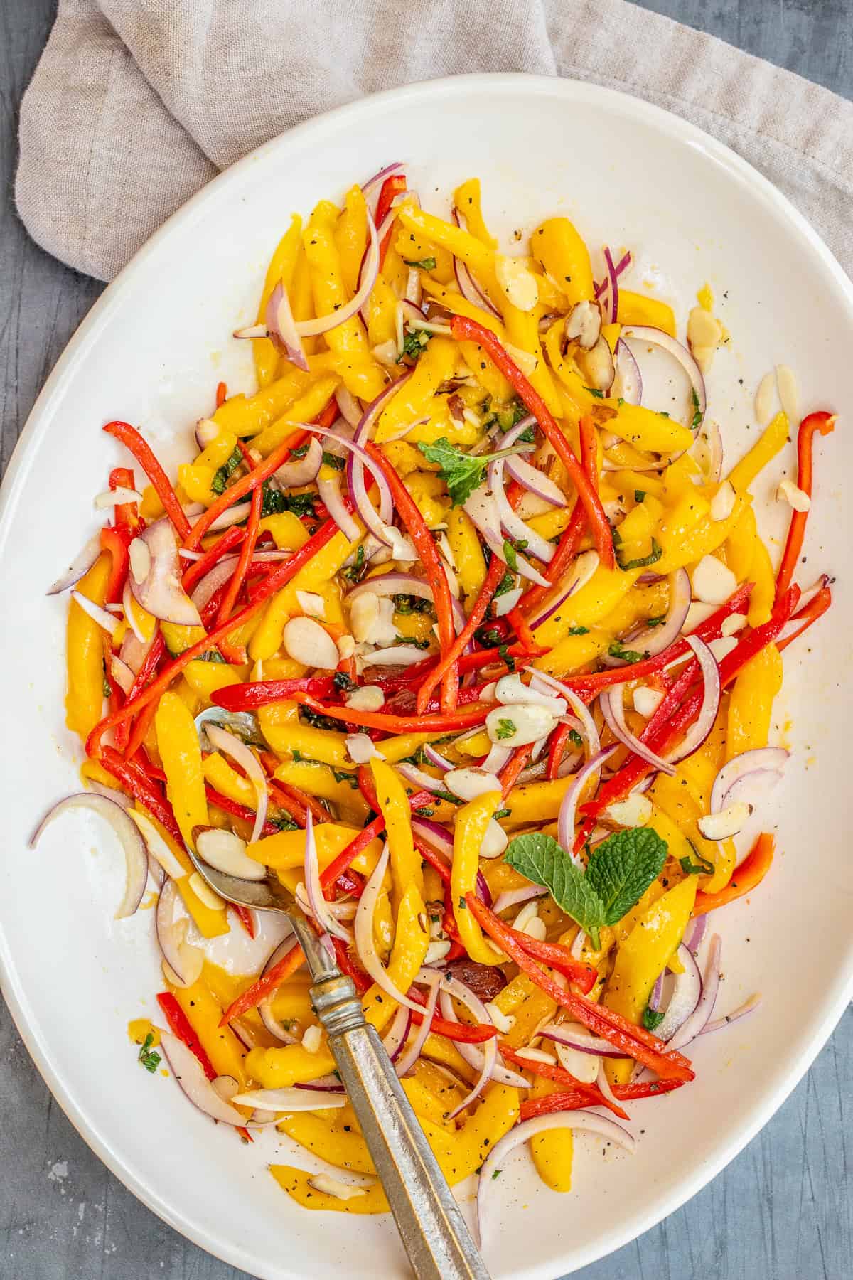 Easy Fresh Mango Salad Recipe - The Perfect Summer Salad A bowl of mango salad topped with almonds.