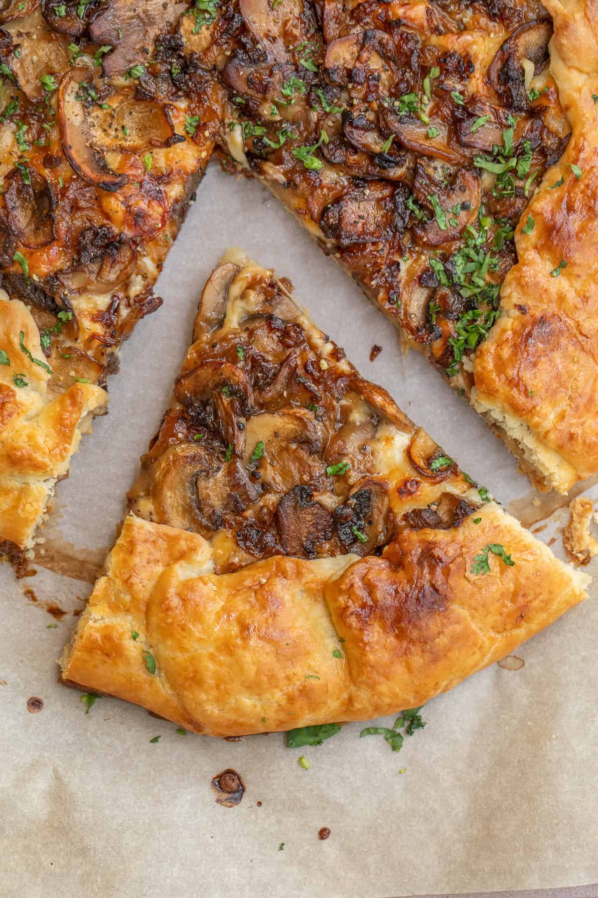 Learn how to make an easy mushroom galette with a golden crust and rich mushroom filling. A slice of cheesy mushroom galette.