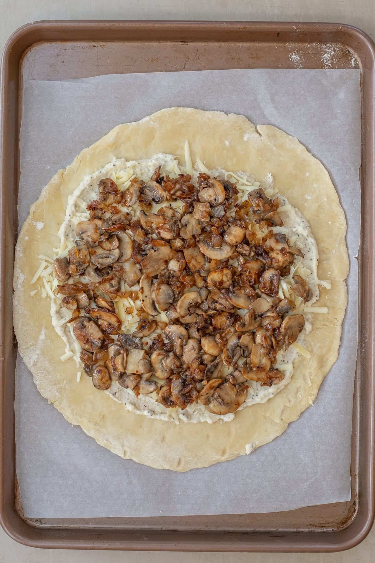The best mushroom galette recipe with a rustic pastry crust and flavorful mushroom filling. The mushroom mixture on top of the homemade galette dough.