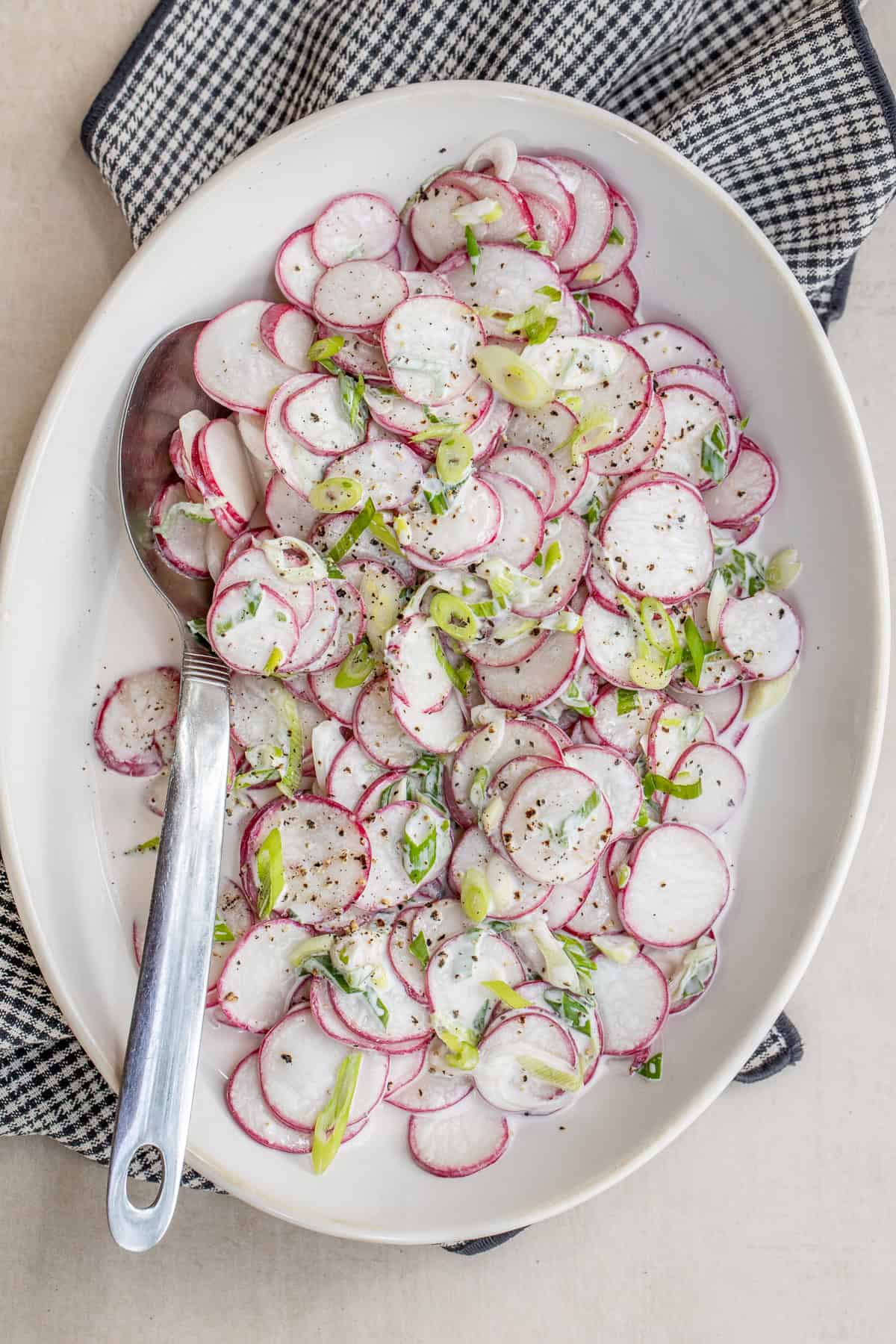 This radish salad is topped with a flavorful homemade dressing. A creamy radish salad in a salad bowl.